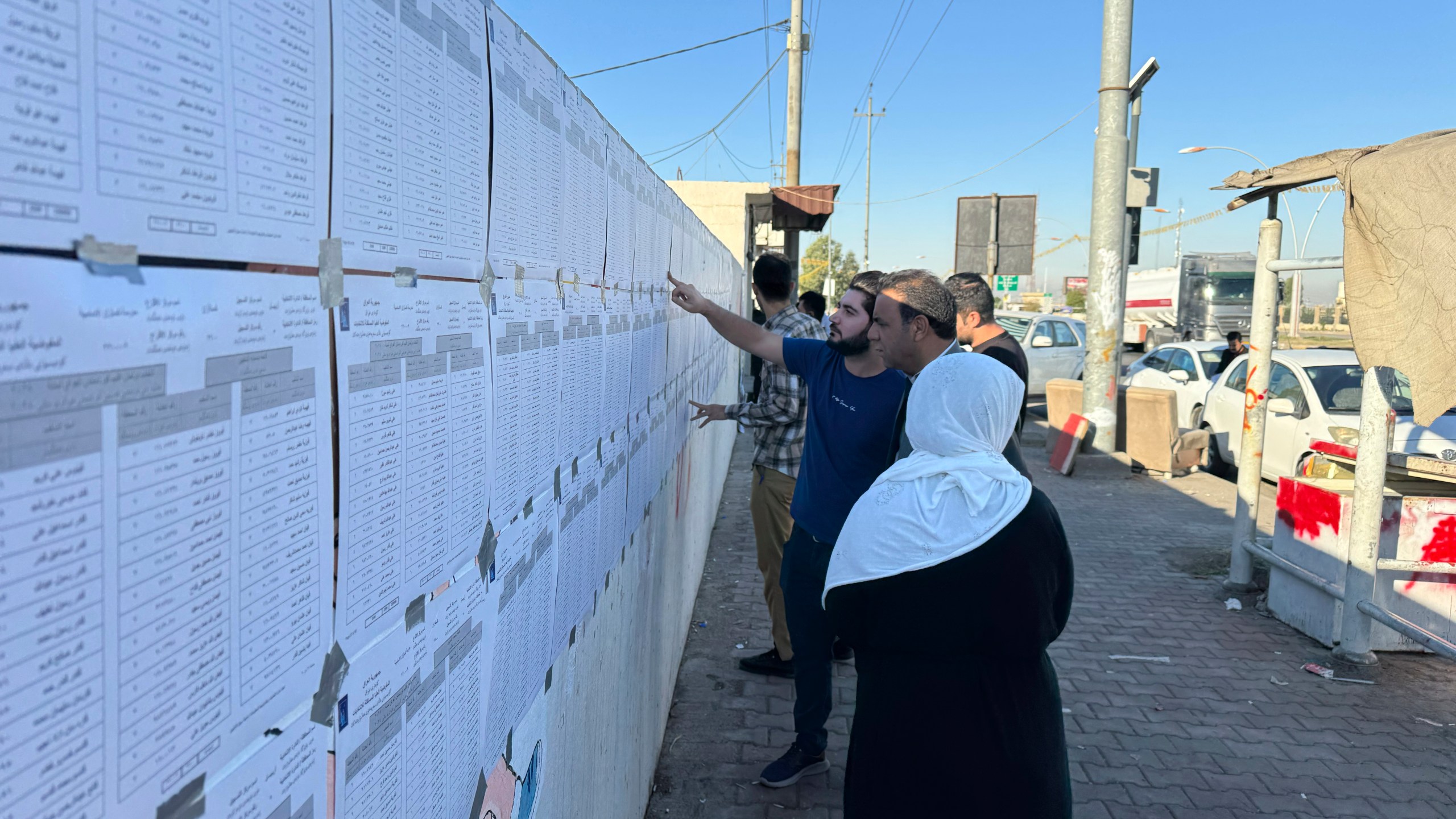 People check candidates lists during parliamentary elections of Iraq’s semi-autonomous northern Kurdish region, in Irbil, Sunday, Oct. 20, 2024. (AP Photo/Salar Salim)