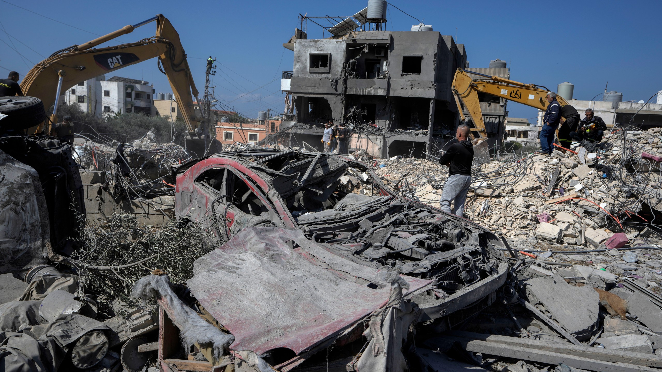 Rescue workers use excavators to remove the rubble of a destroyed building that was hit Tuesday night in an Israeli airstrike, as they search for victims in Sarafand, south Lebanon, Wednesday, Oct. 30, 2024. (AP Photo/Bilal Hussein)