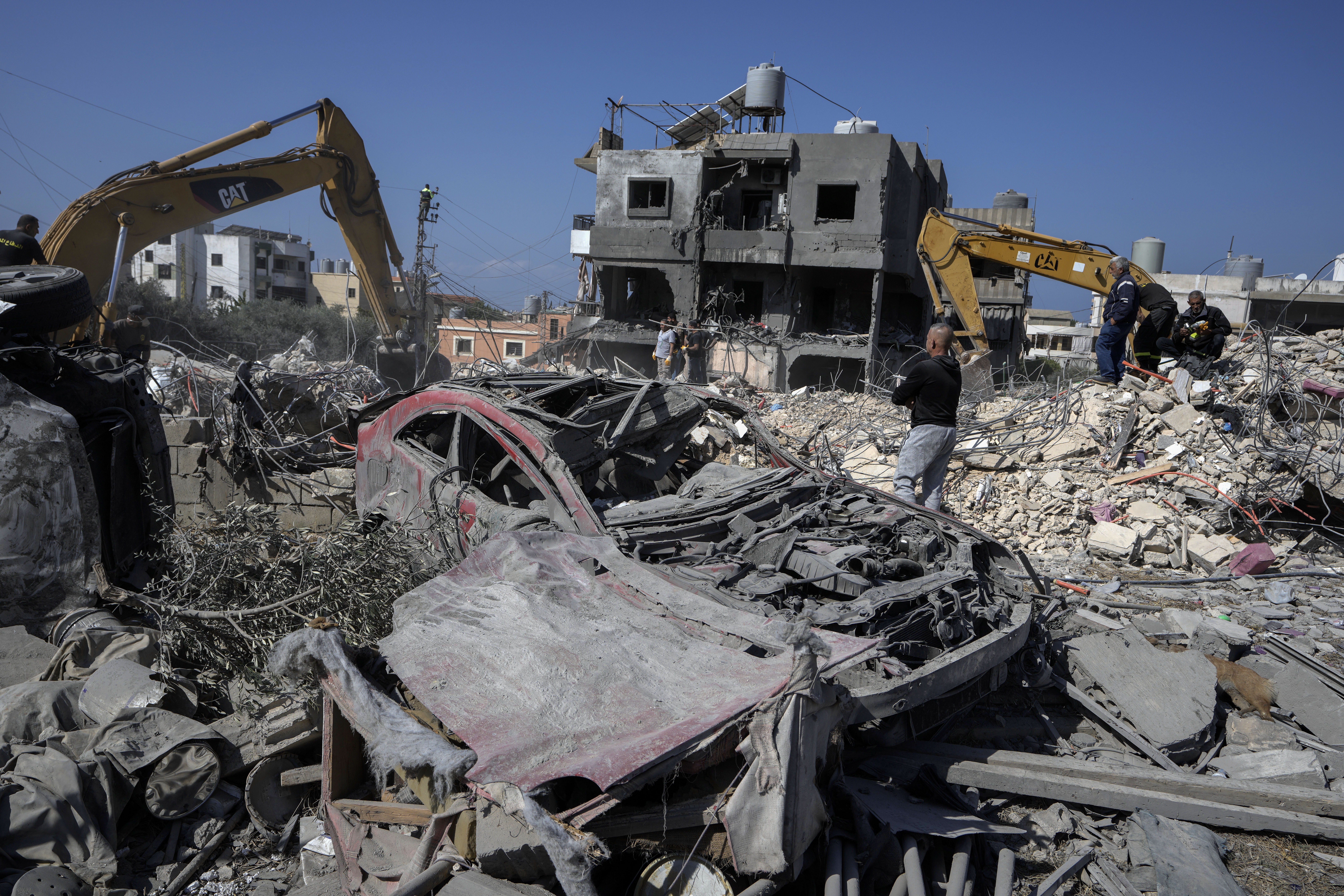 Rescue workers use excavators to remove the rubble of a destroyed building that was hit Tuesday night in an Israeli airstrike, as they search for victims in Sarafand, south Lebanon, Wednesday, Oct. 30, 2024. (AP Photo/Bilal Hussein)