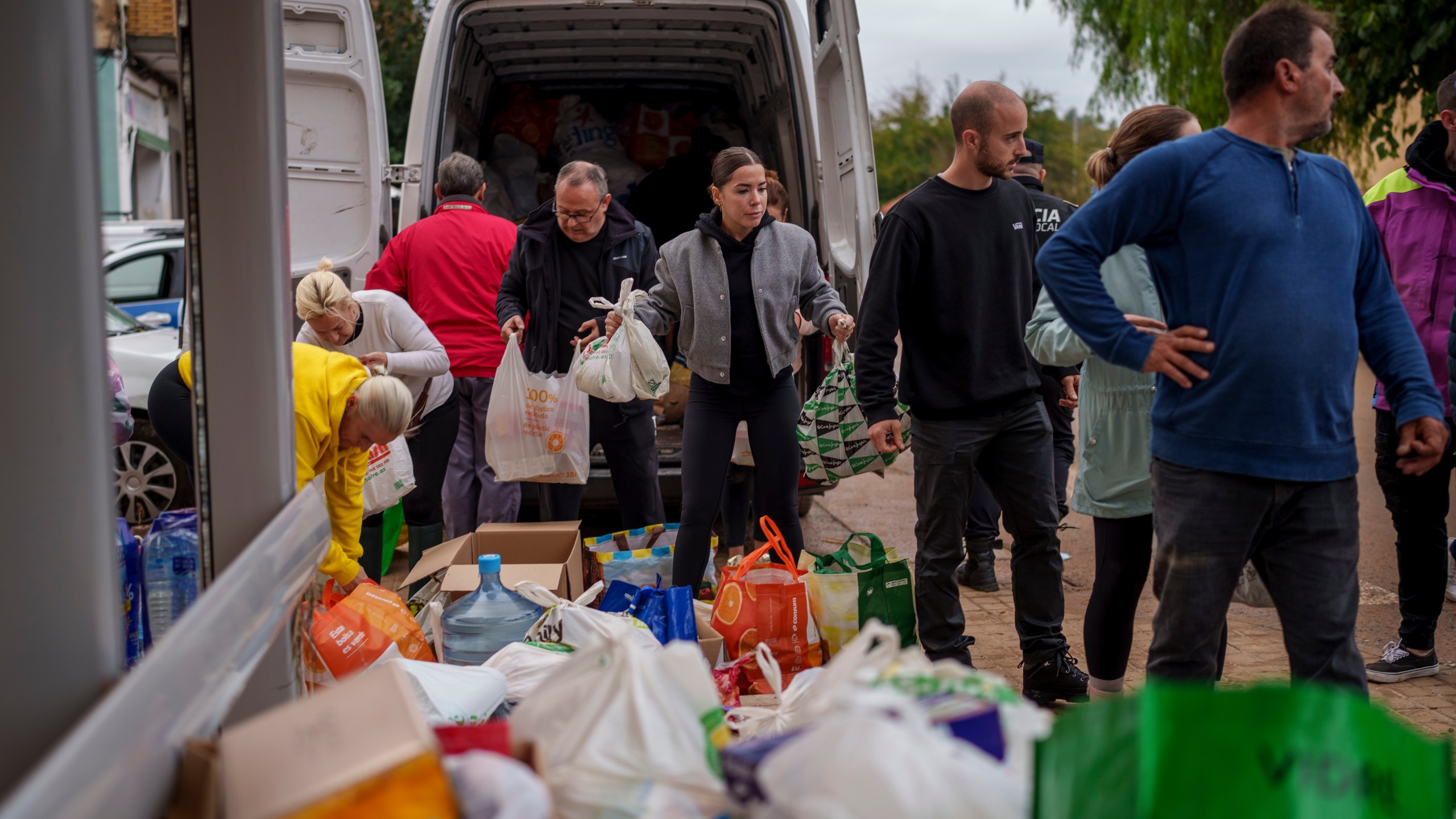 People collect food in an area affected by floods in Chiva, Spain, Friday, Nov. 1, 2024. (AP Photo/Manu Fernandez)