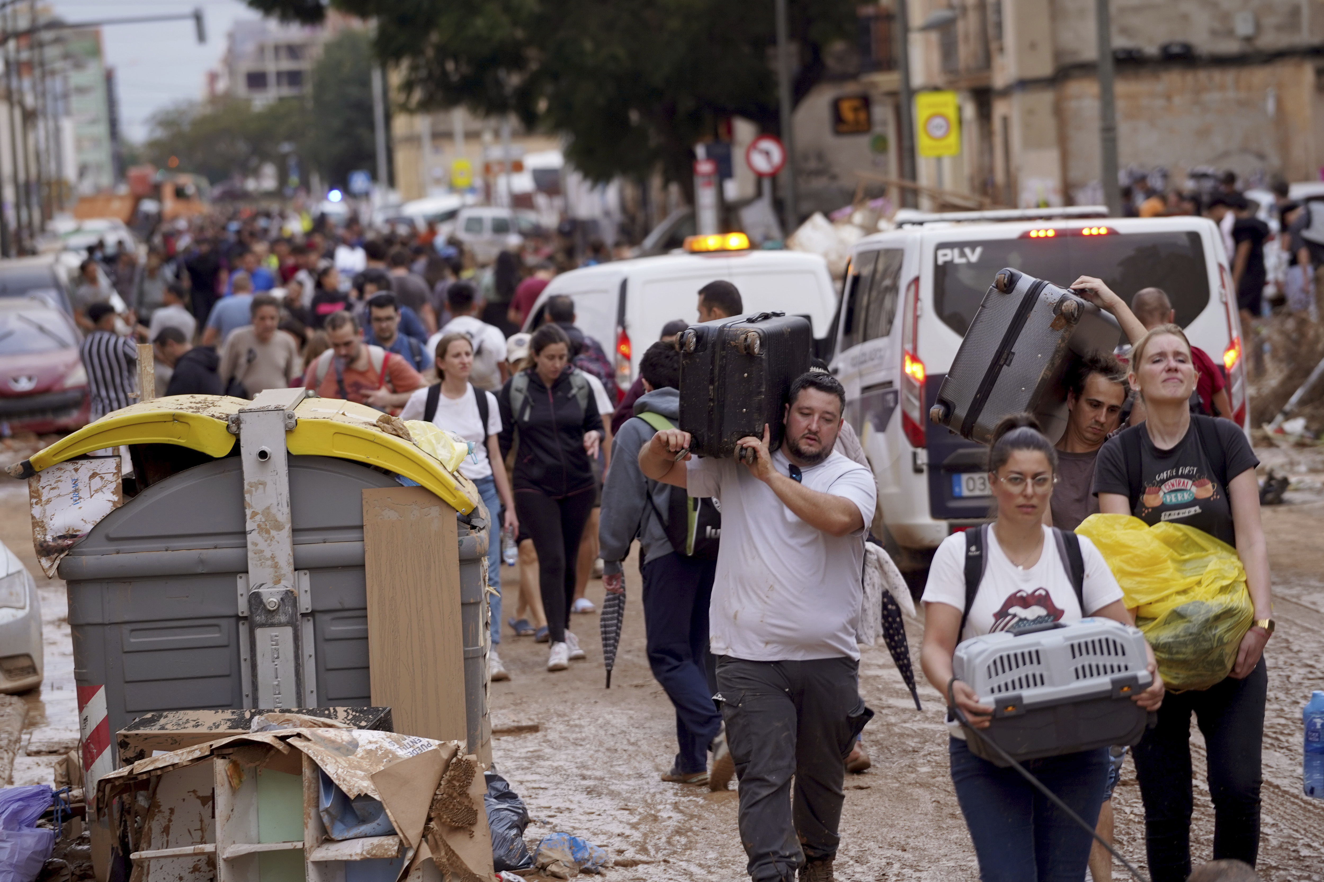 Residents carry their belongings as they leave their houses affected by floods in Valencia, Spain, Thursday, Oct. 31, 2024. (AP Photo/Alberto Saiz)