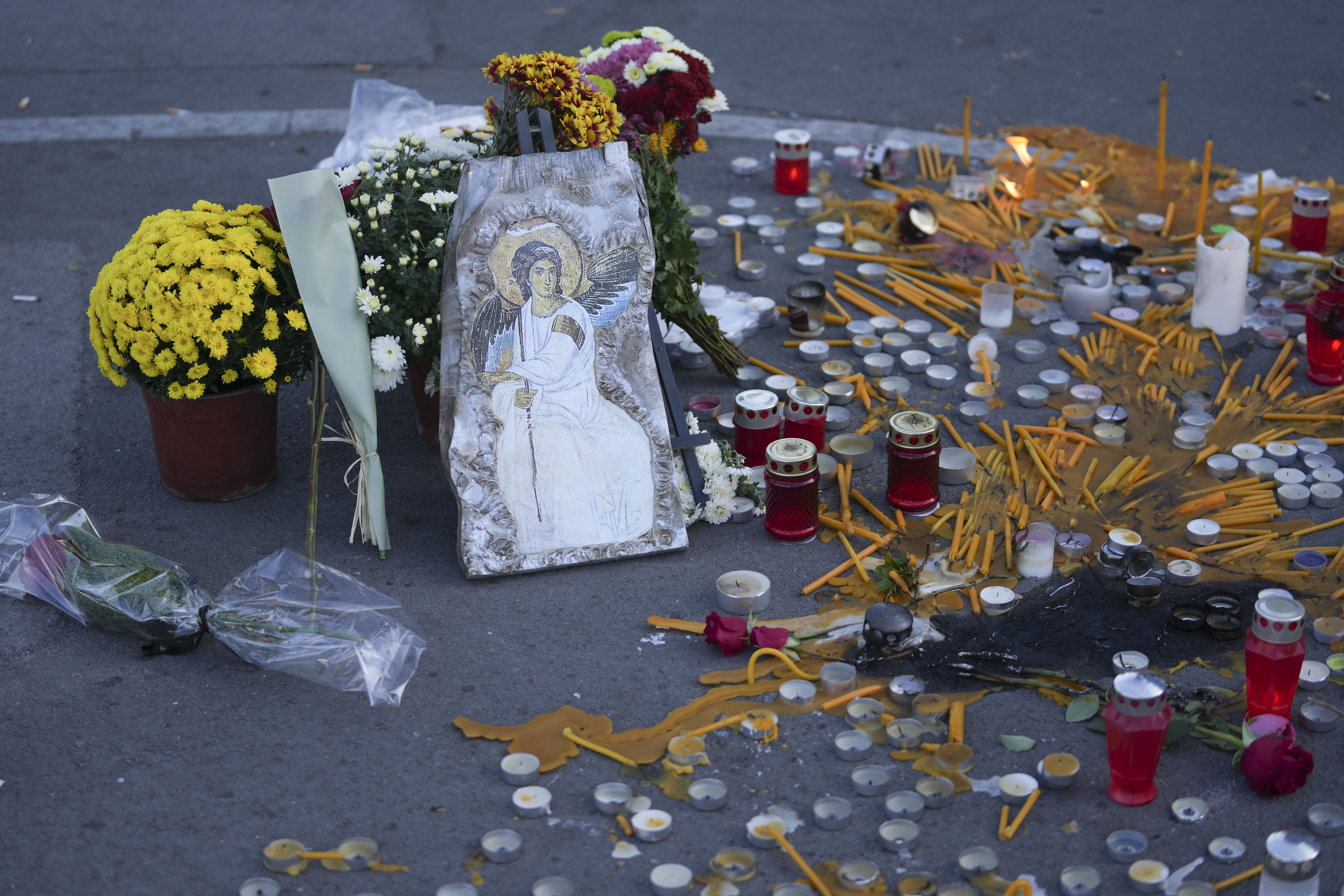 La imagen de un santo ortodoxo y velas, en un monumento de recuerdo improvisado a las víctimas del derrumbe de un techo en una estación de tren el viernes, en Novi Sad, Serbia, el 2 de noviembre de 2024. (AP Foto/Darko Vojinovic)