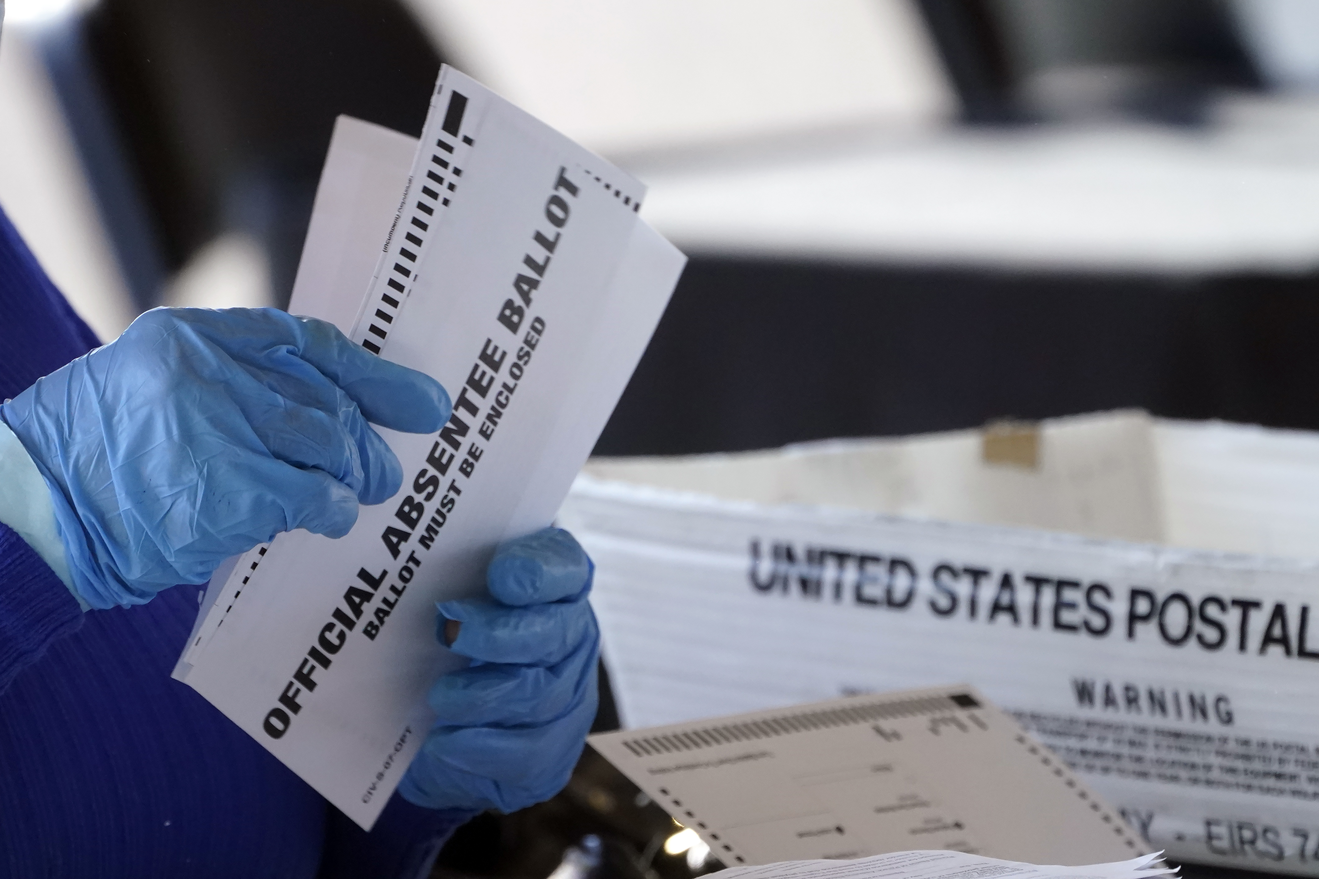 FILE - A worker at the Fulton County Board of Registration and Elections works to process absentee ballots at the State Farm Arena, Nov. 2, 2020, in Atlanta. (AP Photo/John Bazemore, File)