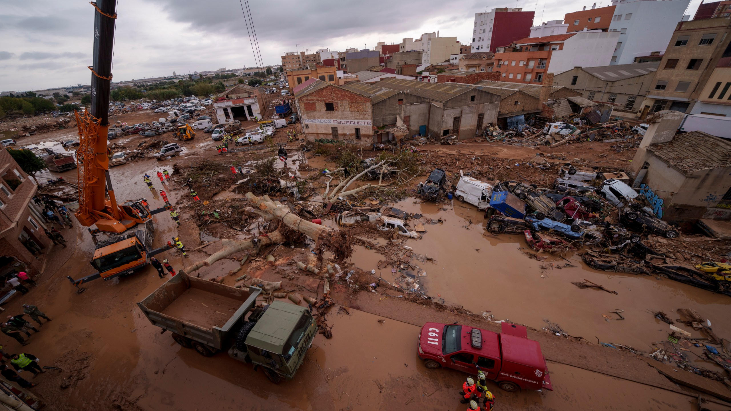 Emergency services remove cars in an area affected by floods in Catarroja, Spain, on Sunday, Nov. 3, 2024. (AP Photo/Manu Fernandez)