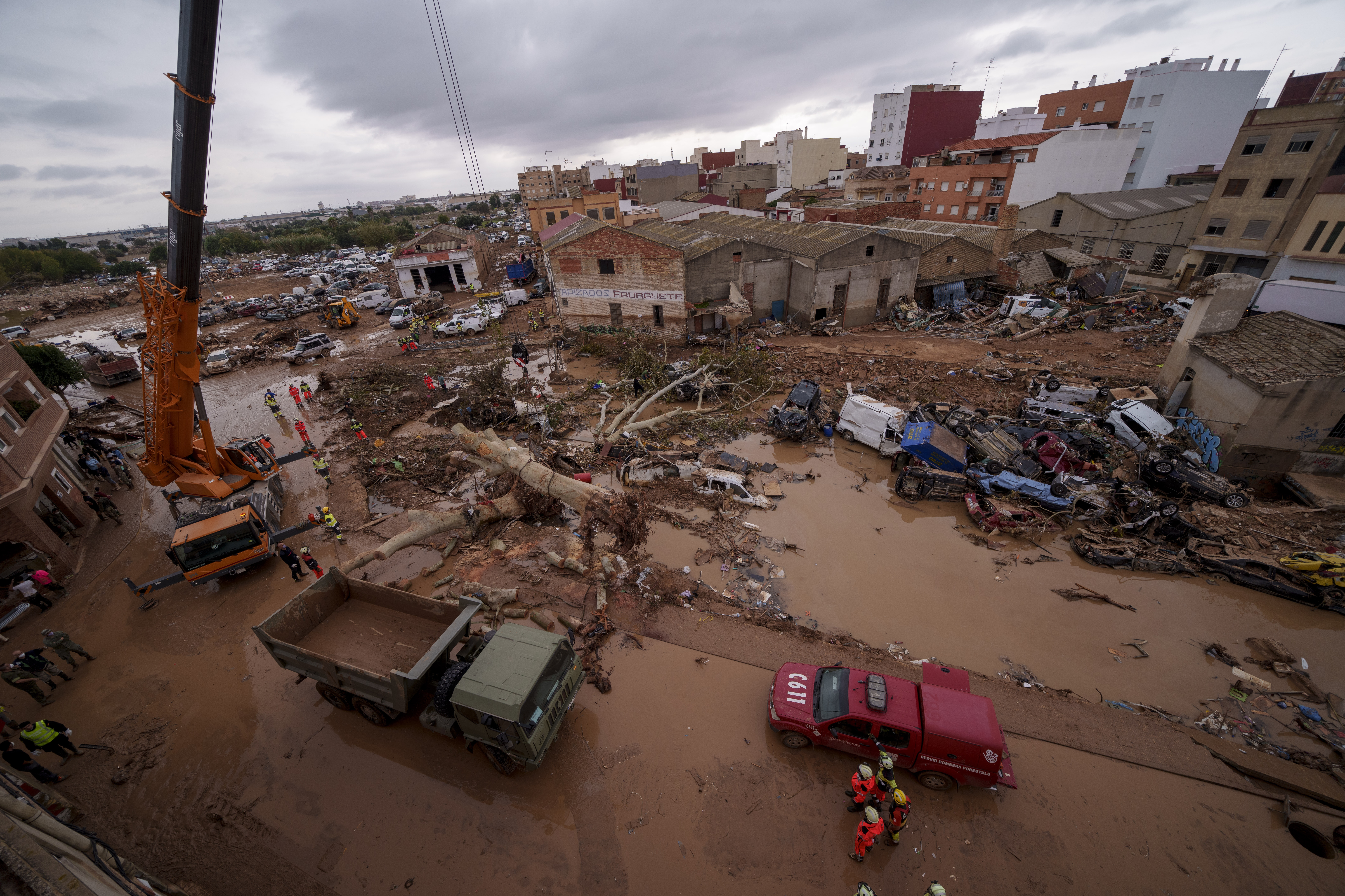 Emergency services remove cars in an area affected by floods in Catarroja, Spain, on Sunday, Nov. 3, 2024. (AP Photo/Manu Fernandez)