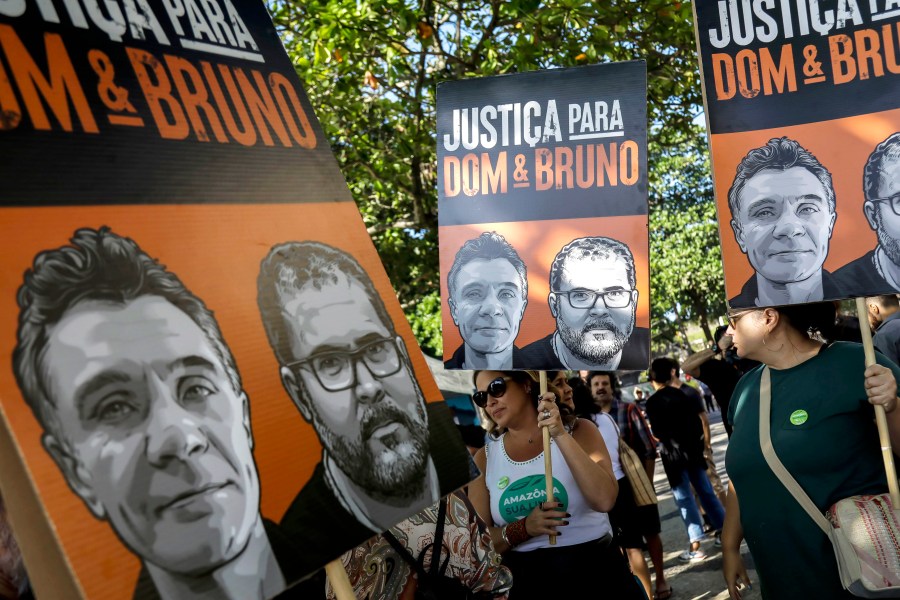 FILE - The relatives of late British journalist Dom Phillips and activists hold banners with his image, left side, and that of Indigenous activist Bruno Pereira, with the Portuguese message: “Justice for Dom and Bruno” during the one-year anniversary since their murders, in Rio de Janeiro, Brazil, June 5, 2023. (AP Photo/Bruna Prado, File)