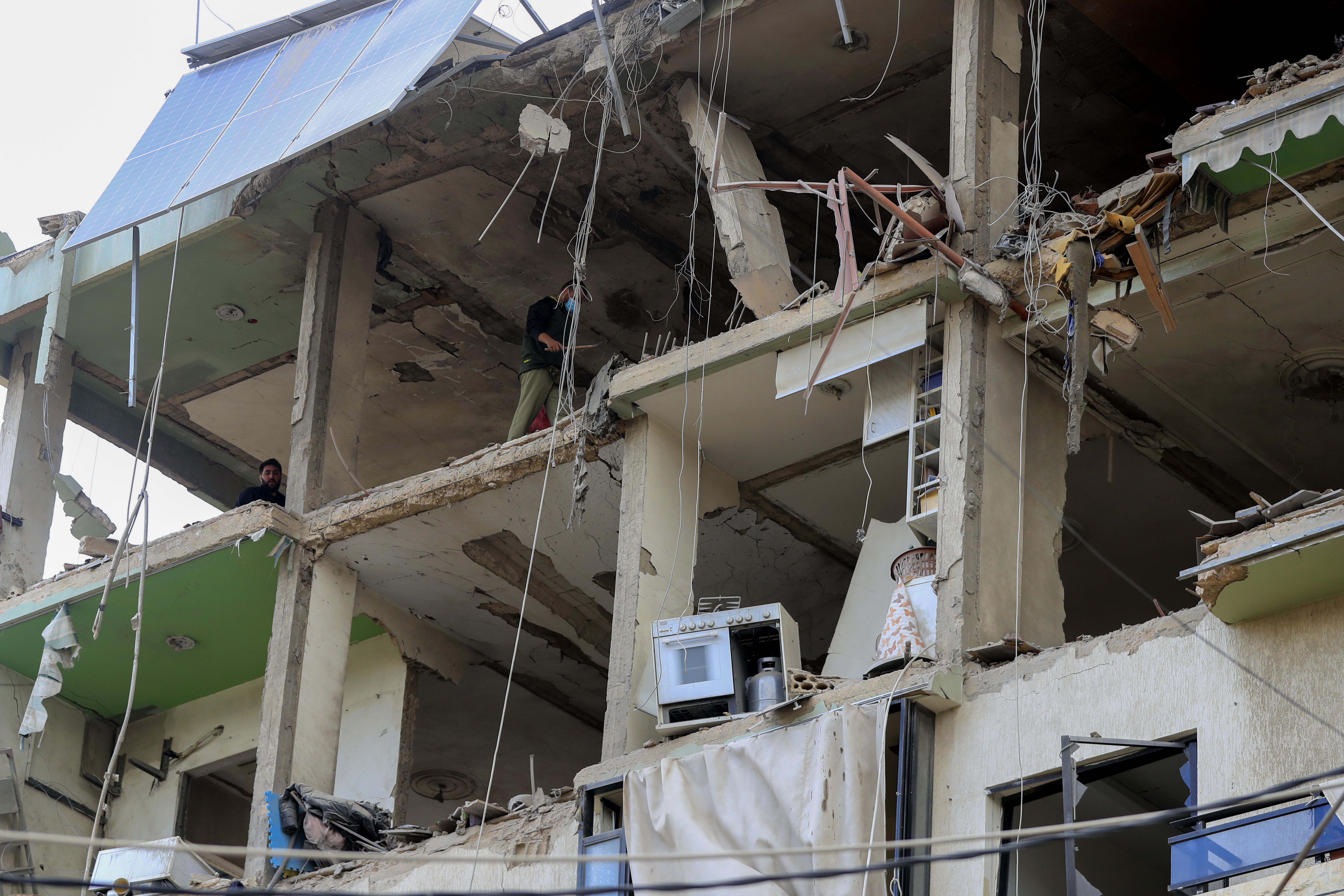 People inspect a destroyed building hit in an Israeli airstrike, in the southern port city of Sidon, Lebanon, Sunday, Nov. 3, 2024. (AP Photo/Mohammed Zaatari)