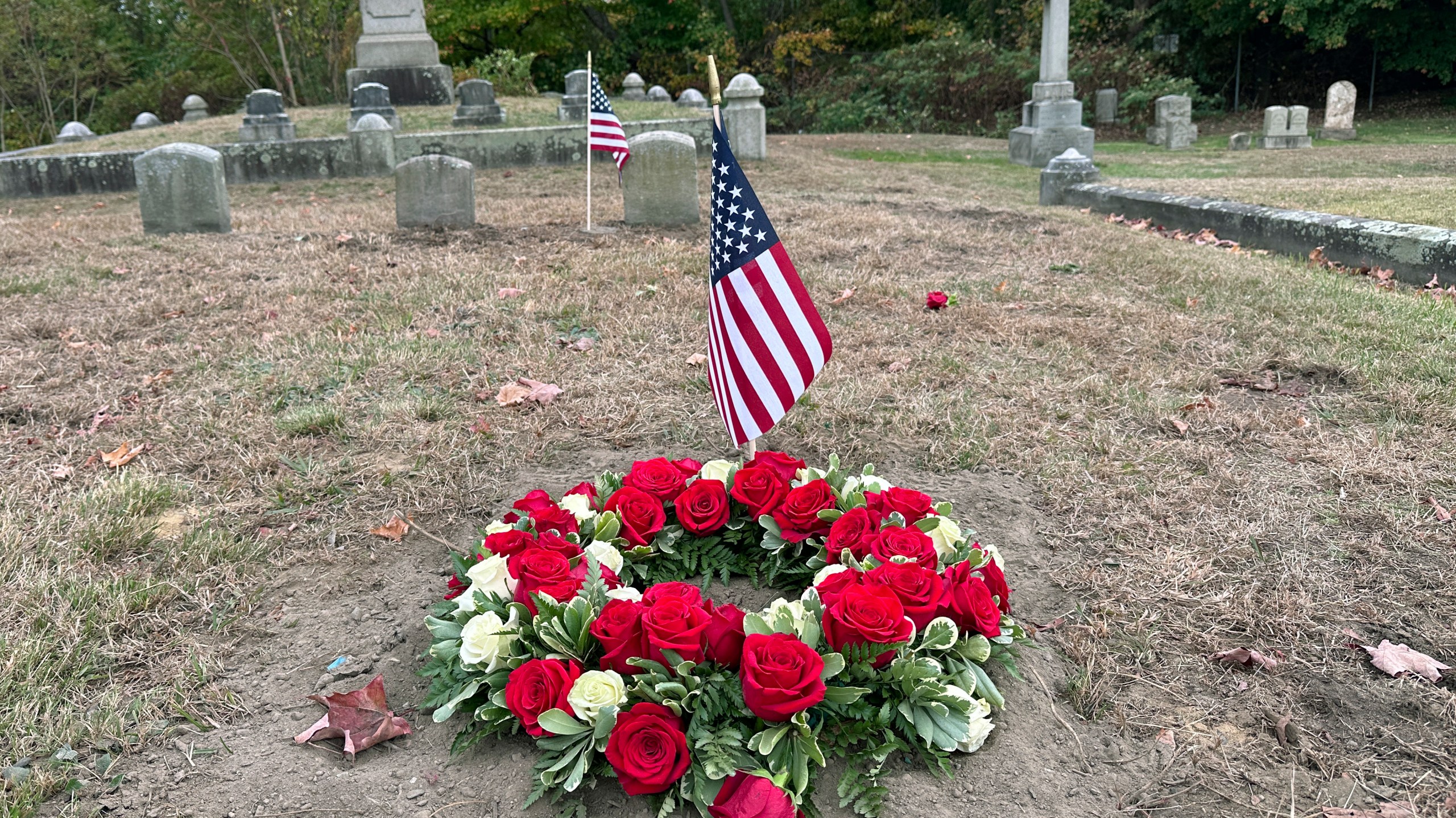 Flowers rest Thursday, Oct. 17, 2024 on the grave of Byron R. Johnson, a Union soldier who was born in Pawtucket, R.I., in 1844 and fought in the Civil War, at Oak Grove Cemetery, in Pawtucket, following Wednesday, Oct. 16, 2024 funeral services for Johnson after his cremated remains were transferred from storage at a cemetery in Seattle. (AP Photo/Michael Casey)