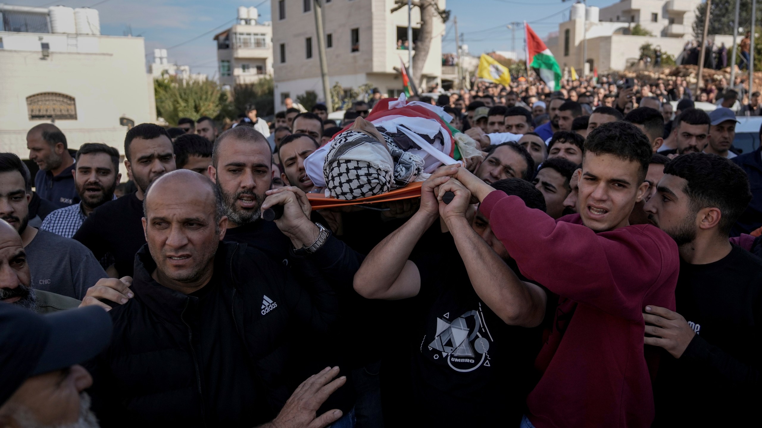 Mourners carry the body of Naji al-Baba,16, who the Palestinian Health Ministry said was killed by Israeli forces in the town of Halhul, West Bank, during his funeral on Monday, Nov. 4, 2024. (AP Photo/Mahmoud Illean)