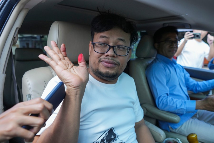 FILE - Cambodian freelance journalist Mech Dara, who was released on bail waves from a car in front of the main provincial prison of Kendal Province, southern Phnom Penh, Cambodia, on Oct. 24, 2024. (AP Photo/Heng Sinith)