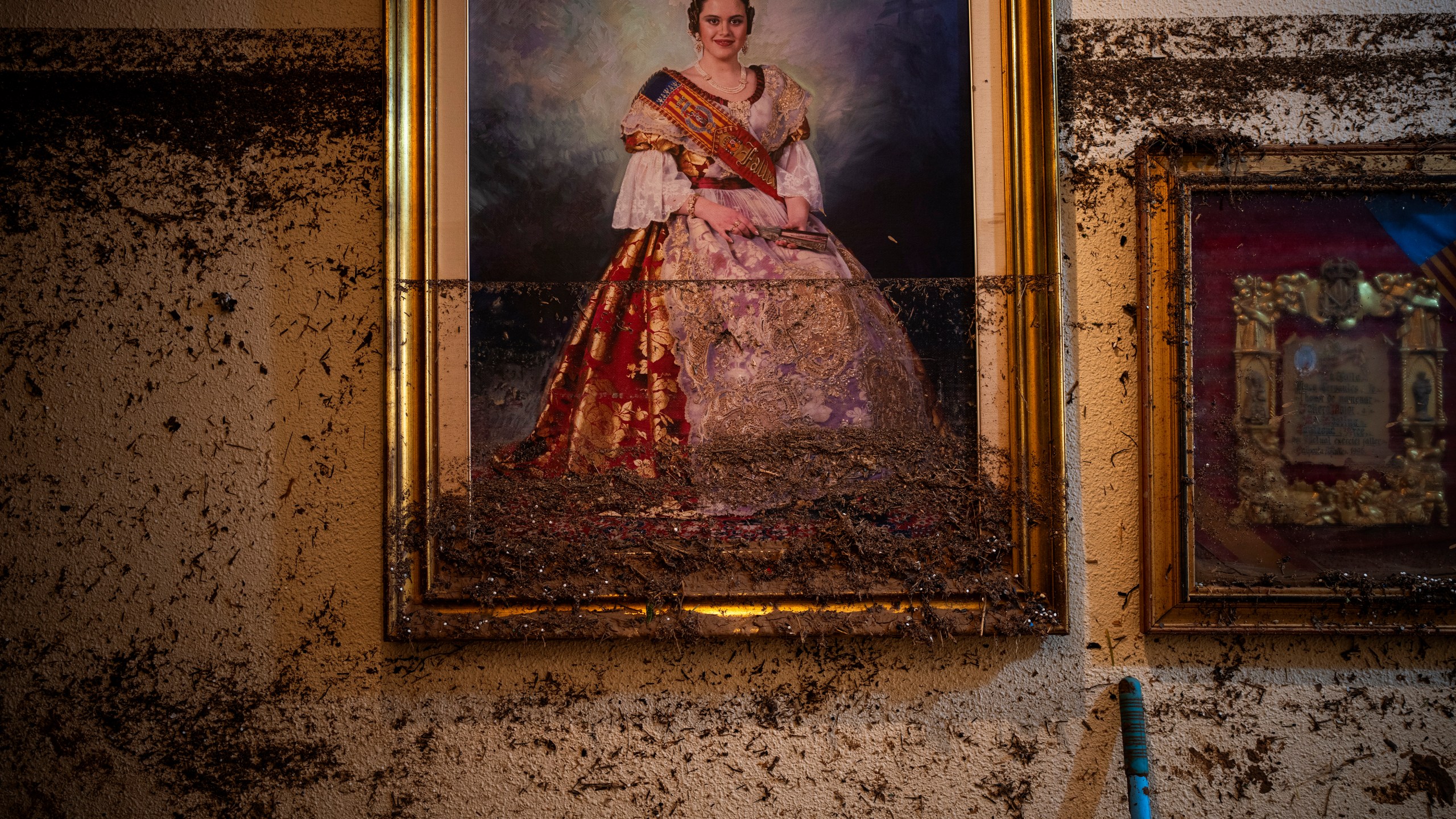 A painting hangs near the water level marker in an area affected by floods in Paiporta, Valencia, Spain, Tuesday, Nov. 5, 2024. (AP Photo/Emilio Morenatti)