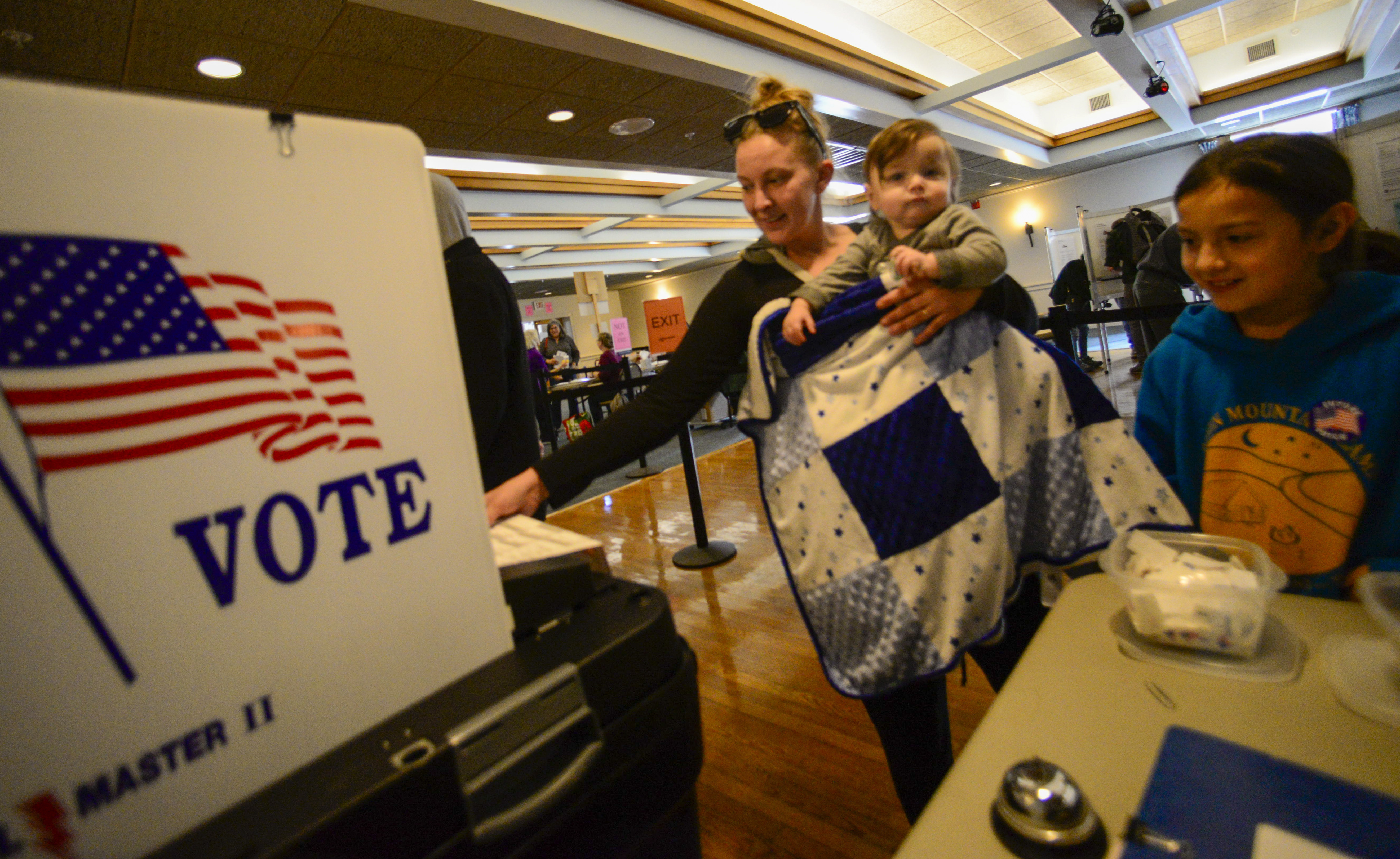 Caitlyn Person of Brattleboro, Vt., surrounded by her two children, Ellie Person, 9, and Wyatt Findlay-Person, 1, casts her ballot at the polling station in Brattleboro on Election Day on Tuesday, Nov. 5, 2024. (Kristopher Radder/The Brattleboro Reformer via AP)