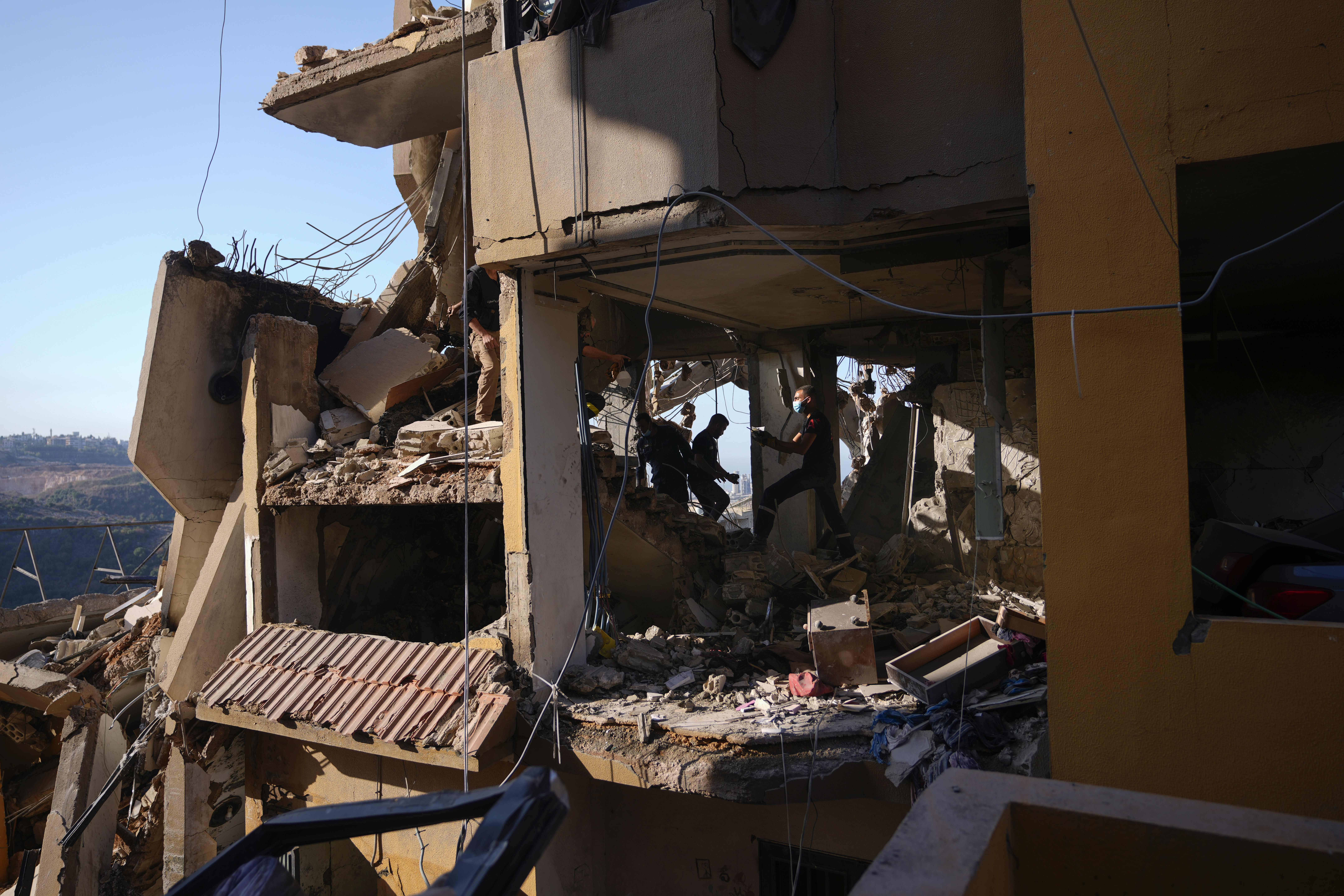 Rescue workers search for victims in the rubble of a destroyed building hit in an Israeli airstrike on Tuesday night, in Barja, Lebanon, Wednesday, Nov. 6, 2024. (AP Photo/Hassan Ammar)