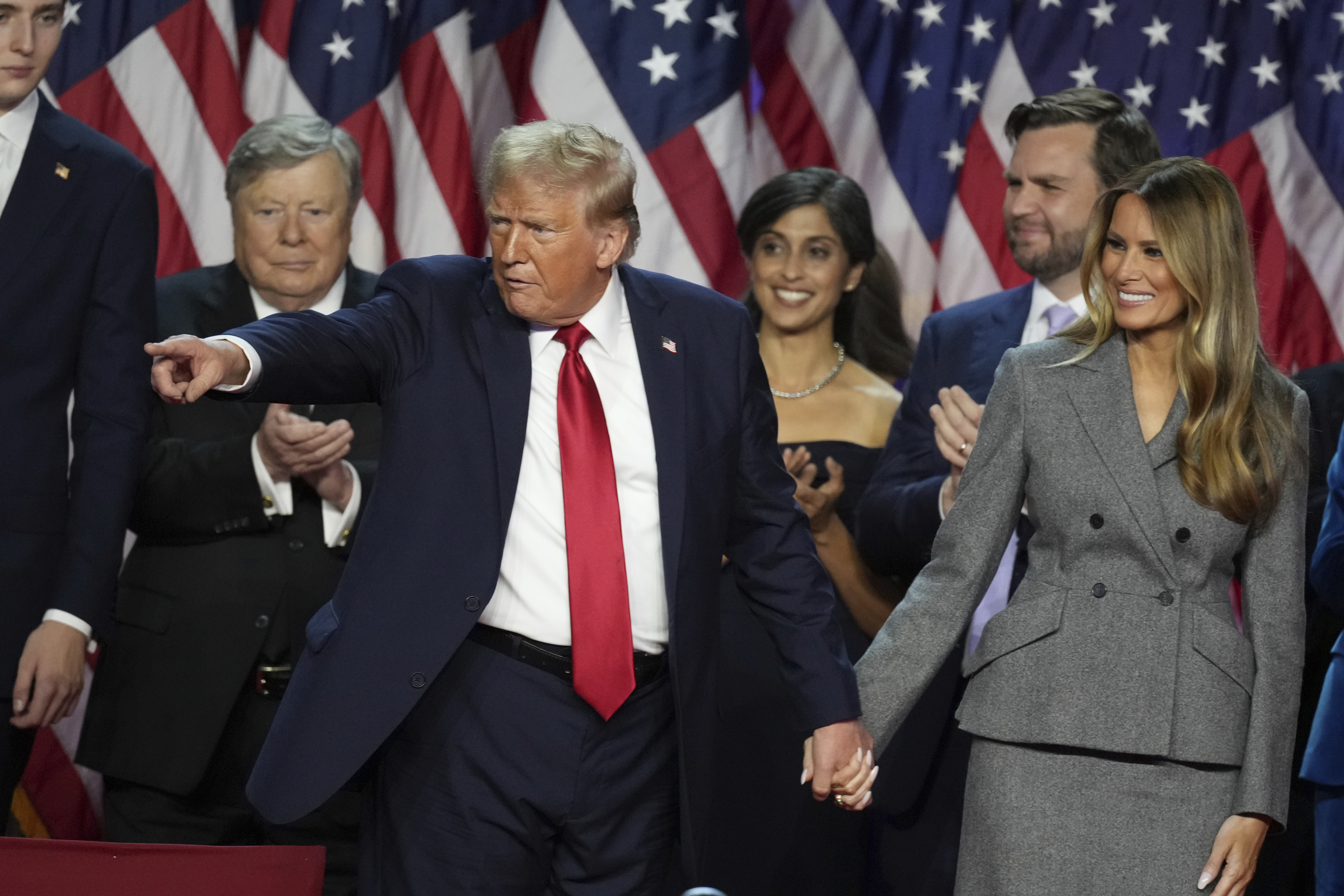 Republican Presidential nominee former President Donald Trump holds hands with former first lady Melania Trump after speaking to supporters at the Palm Beach County Convention Center during an election night watch party, Wednesday, Nov. 6, 2024, in West Palm Beach, Fla. (AP Photo/Lynne Sladky)