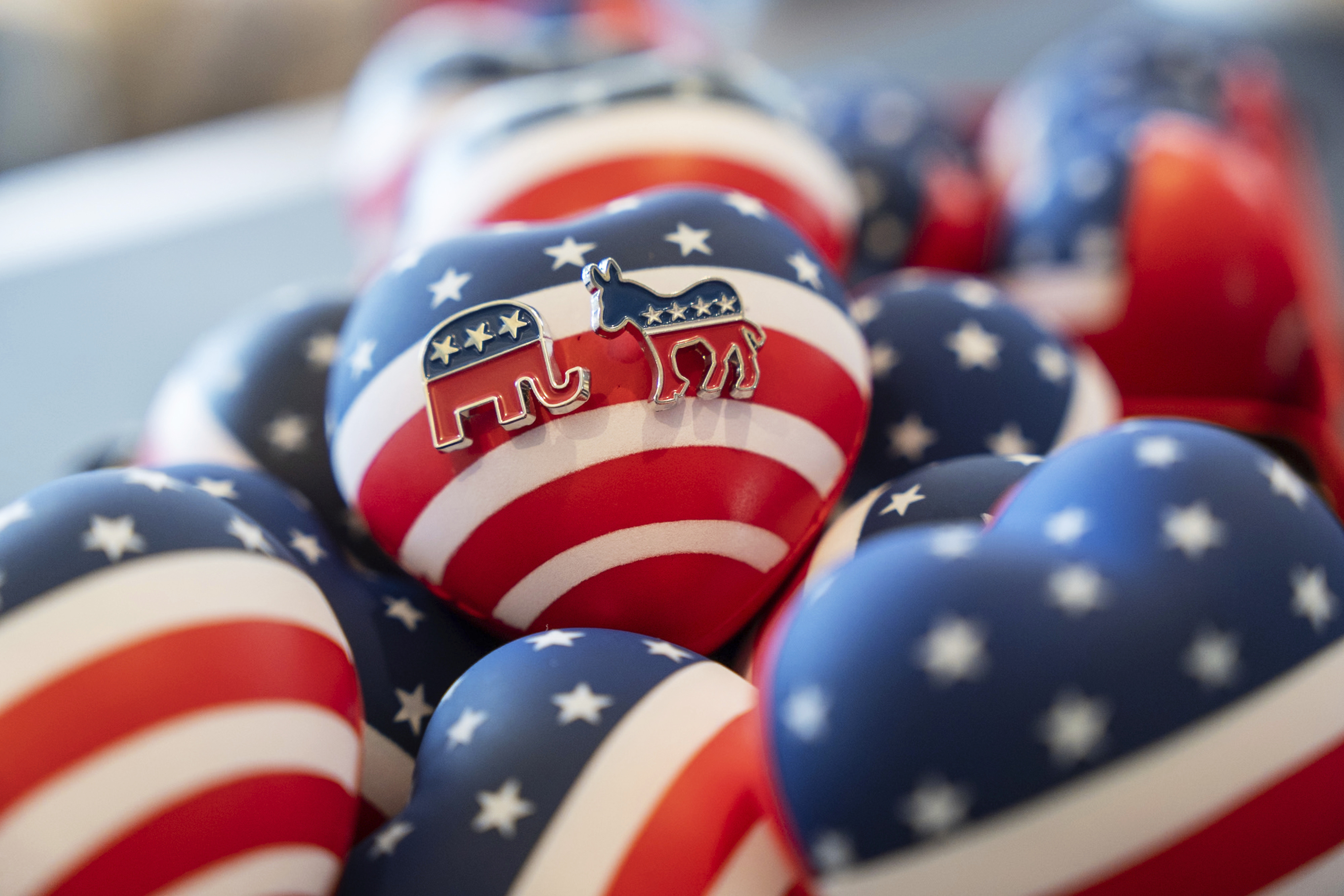 Republican and Democratic Party pins are displayed at a venue as guests watch a television broadcast of U.S. elections in Hong Kong, Wednesday, Nov. 6, 2024. (AP Photo/Chan Long Hei)