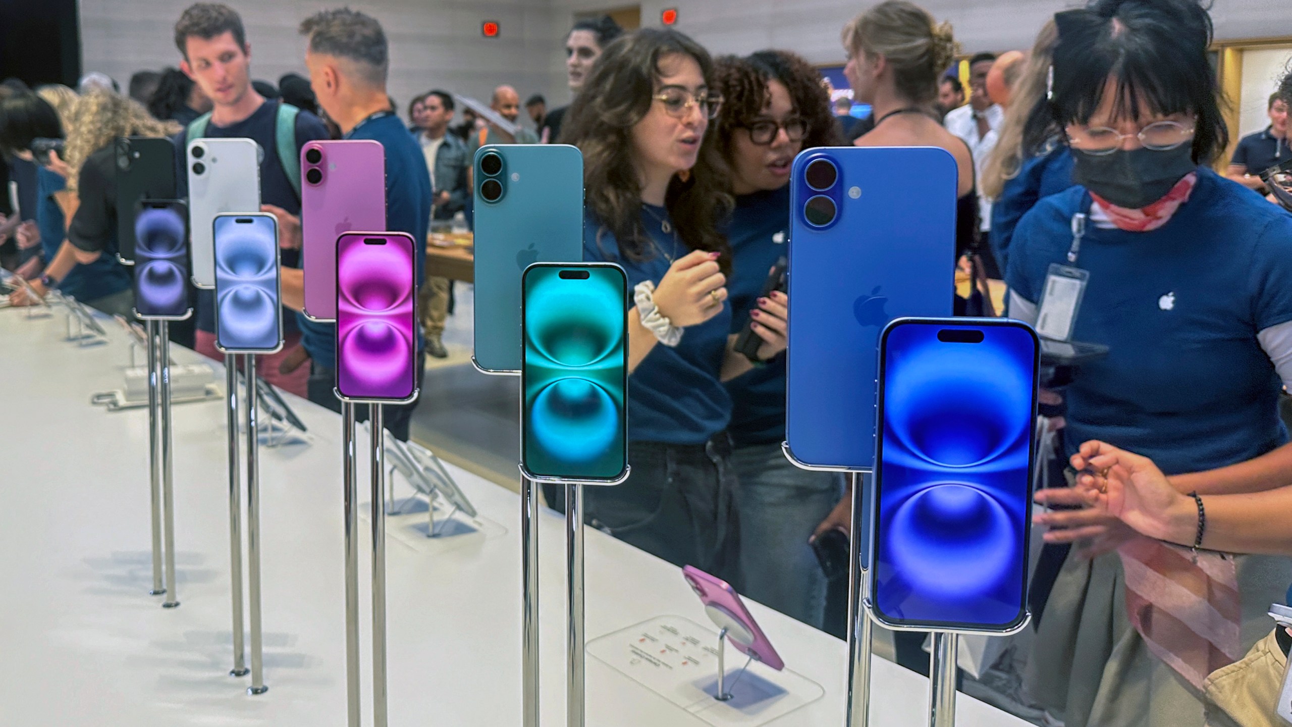 FILE - People gather near a display of iPhone 16's at the Apple Store on 5th Ave. in New York on September 20, 2024.(AP Photo/Ted Shaffrey, File)