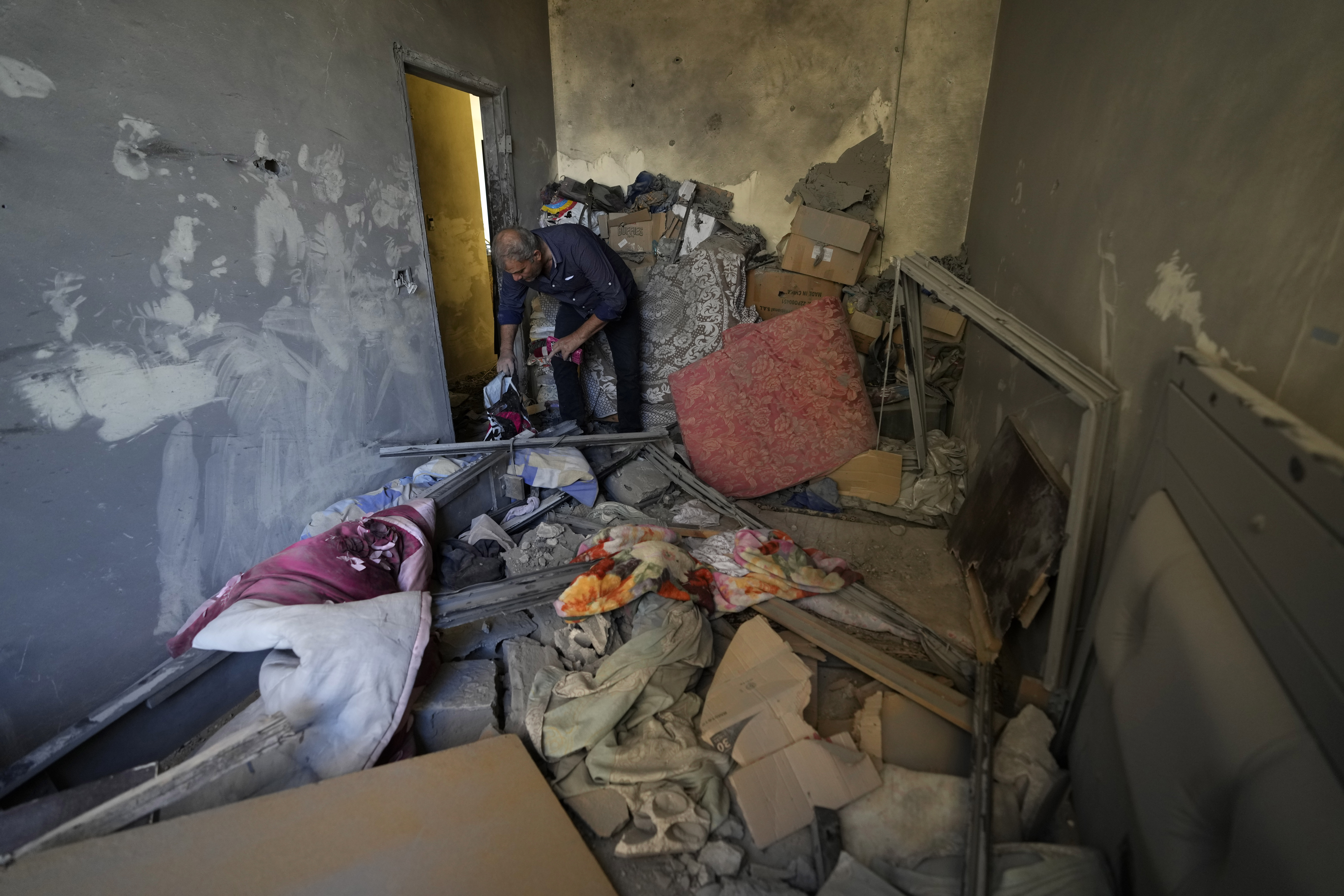 A resident of a building damaged in an Israeli airstrike on Tuesday night, returns to collect his family's belongings in Barja, Lebanon, Wednesday, Nov. 6, 2024. (AP Photo/Hassan Ammar)