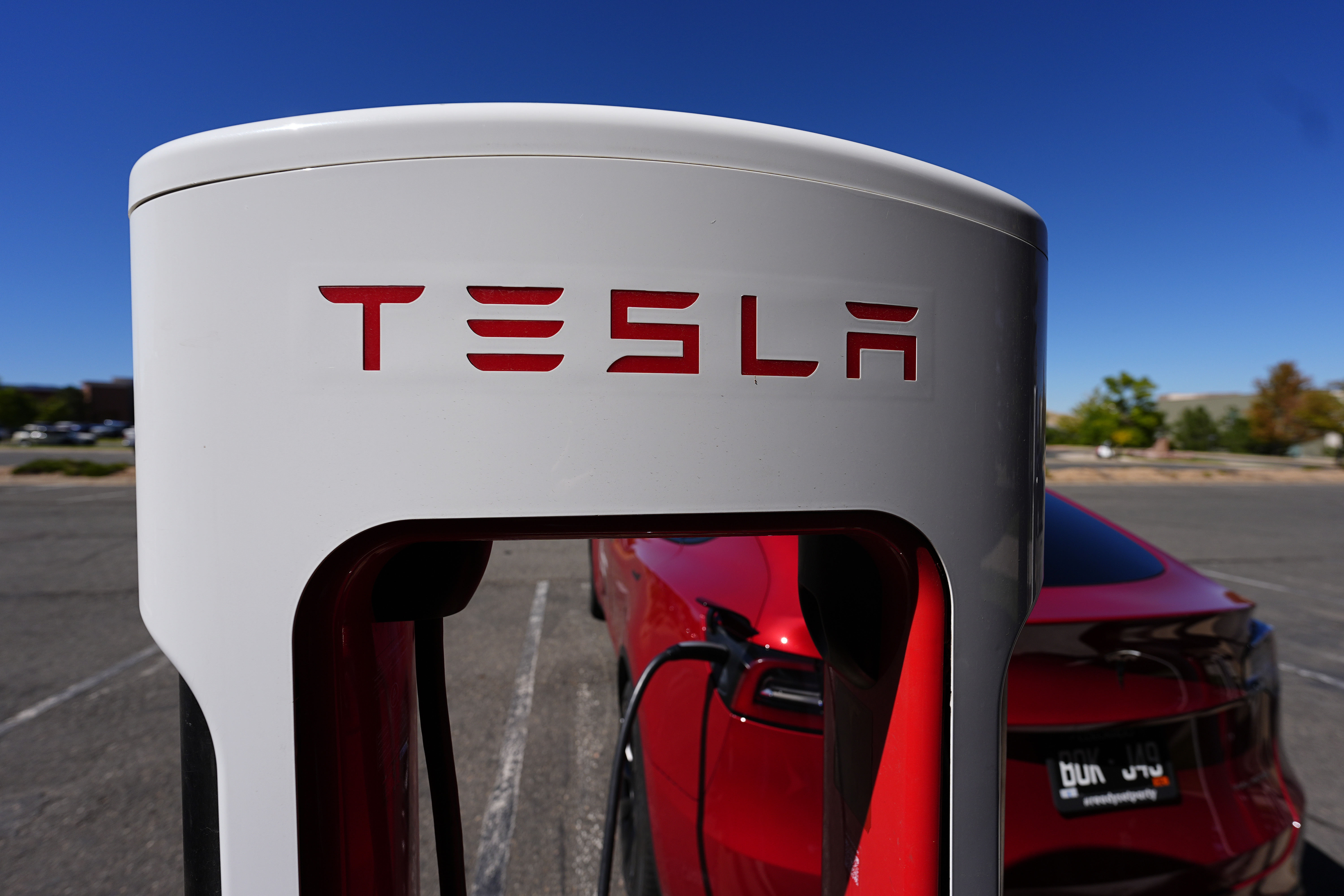 FILE - A Tesla Model 3 charges at a Tesla supercharging station in the parking lot of an outlet mall Sept. 25, 2024, in Lakewood, Colo. (AP Photo/David Zalubowski, File)