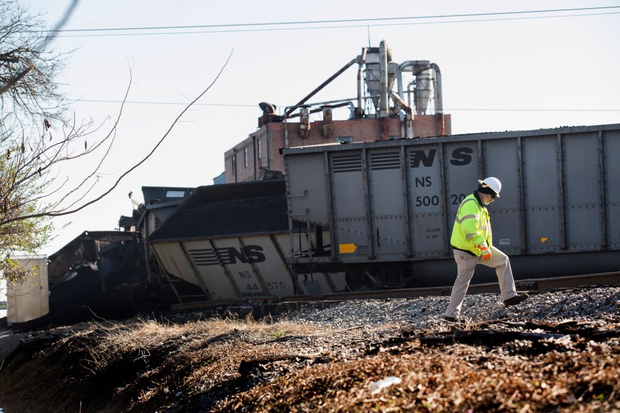 FILE - A Norfolk Southern worker walks next to the scene of a multi-car coal train derailment near Suffolk, Va., on Feb. 4, 2017. (Bill Tiernan/The Virginian-Pilot via AP, File)