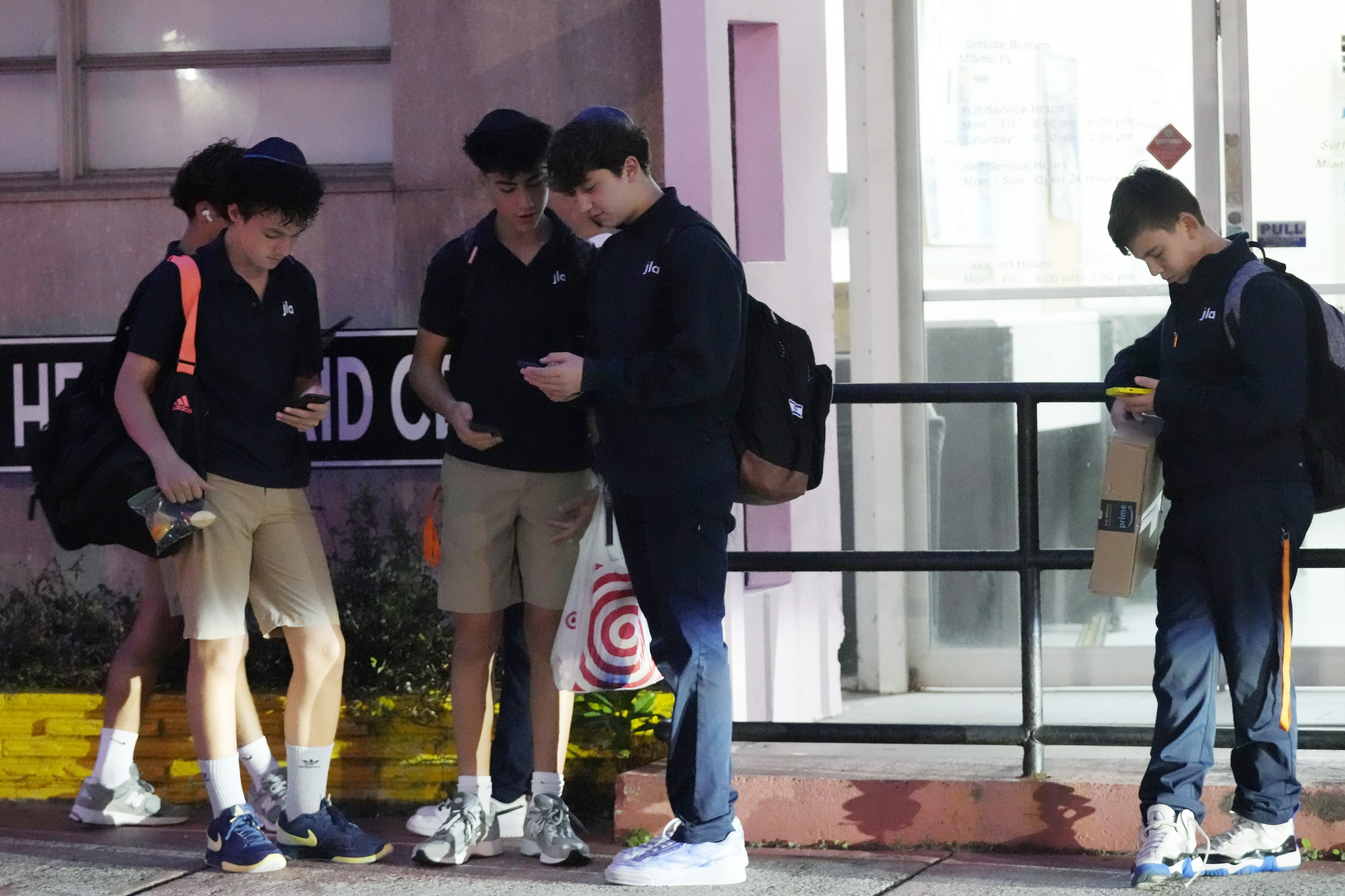 Students wait for their bus to school, Tuesday, Oct. 29, 2024, in Surfside, Fla. Daylight saving time ends at 2 a.m. local time Sunday, Nov. 3. Standard time will last until March 9. (AP Photo/Marta Lavandier)