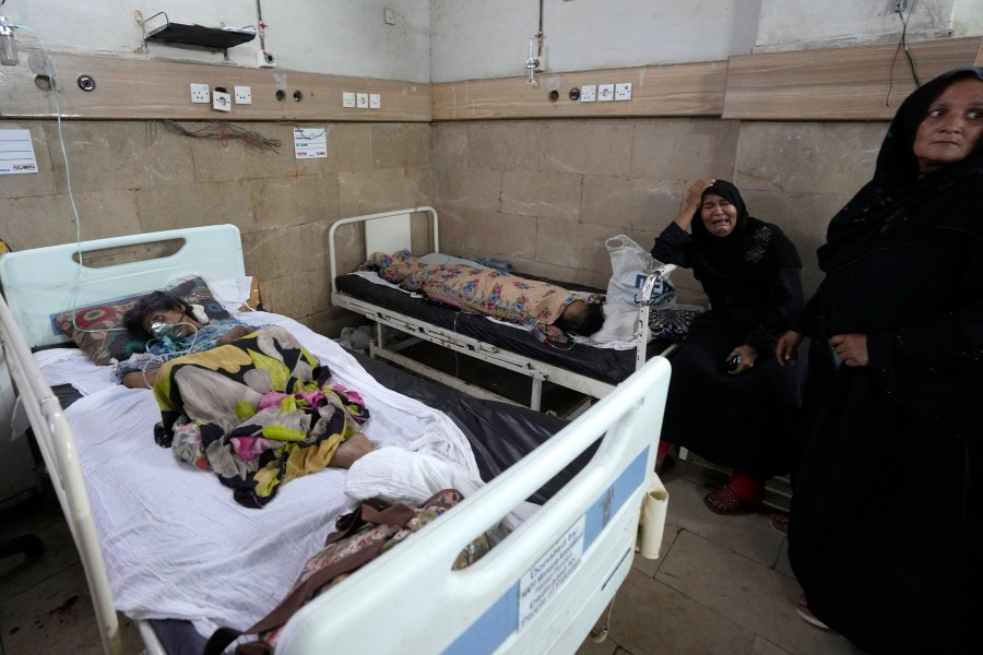 FILE - A woman, center, weeps as patients of heatstroke receive treatment at a hospital in Karachi, Pakistan, June 25, 2024. (AP Photo/Fareed Khan, File)