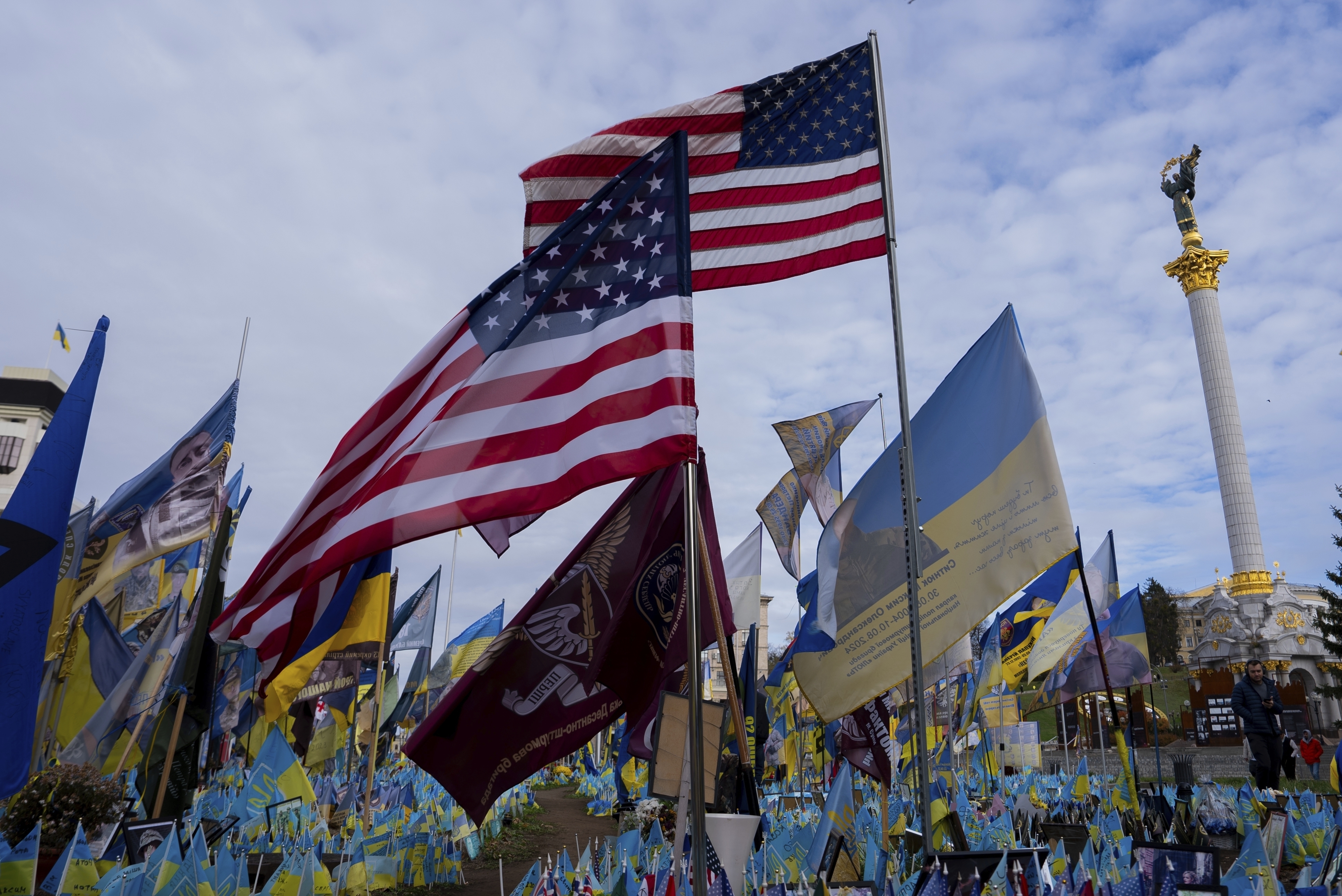 American and Ukrainian flags placed in honour of fallen servicemen flutter in the wind in front of statue in central square, in Kyiv, Ukraine, Tuesday, Nov. 5, 2024. (AP Photo/Alex Babenko)