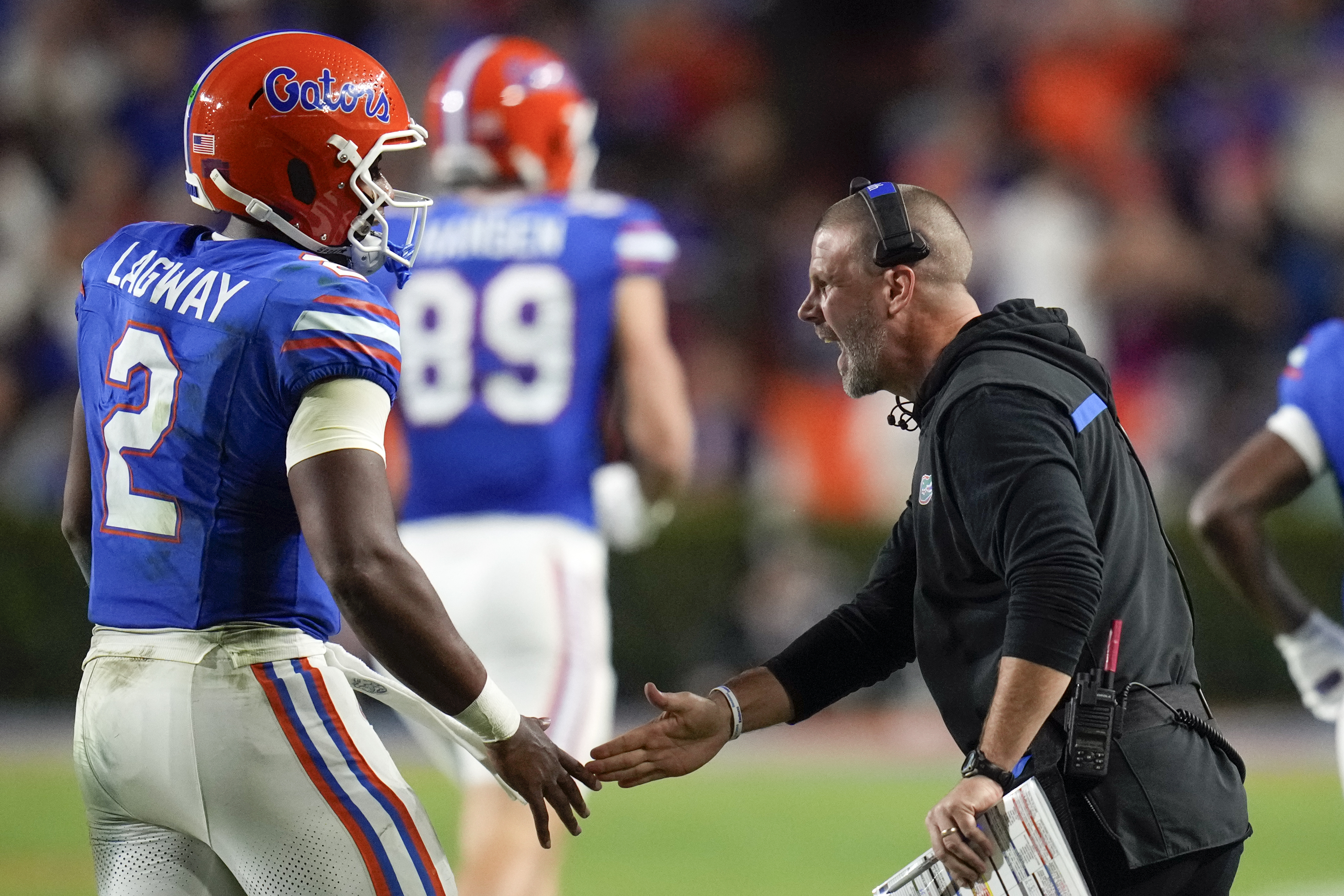 Florida head coach Billy Napier, right, greets quarterback DJ Lagway (2) as he comes off the field during the first half of an NCAA college football game against Kentucky, Saturday, Oct. 19, 2024, in Gainesville, Fla. (AP Photo/John Raoux)