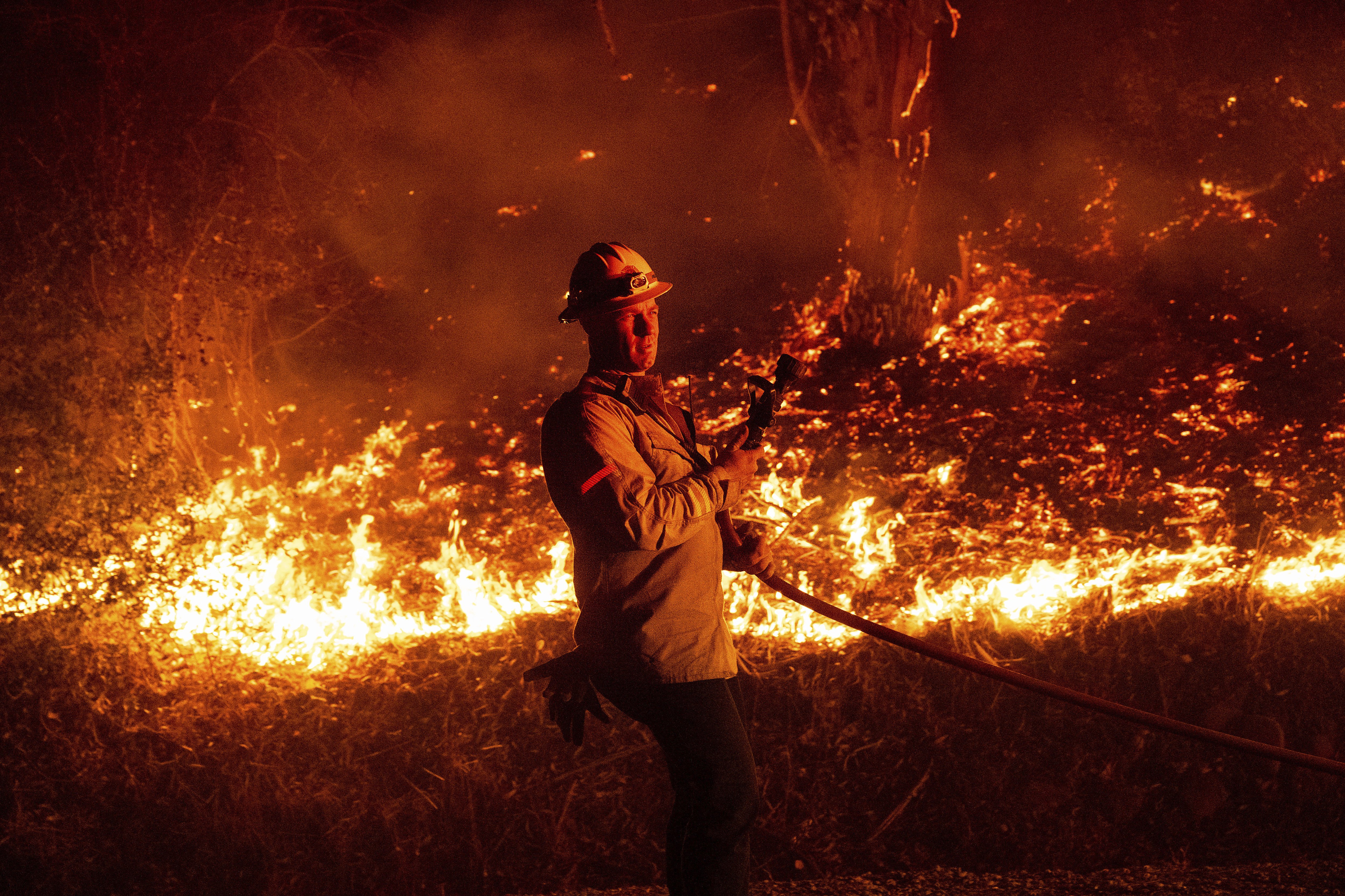 A firefighter prepares to douse flames while battling the Mountain Fire on Wednesday, Nov. 6, 2024, in Santa Paula, Calif. (AP Photo/Noah Berger)