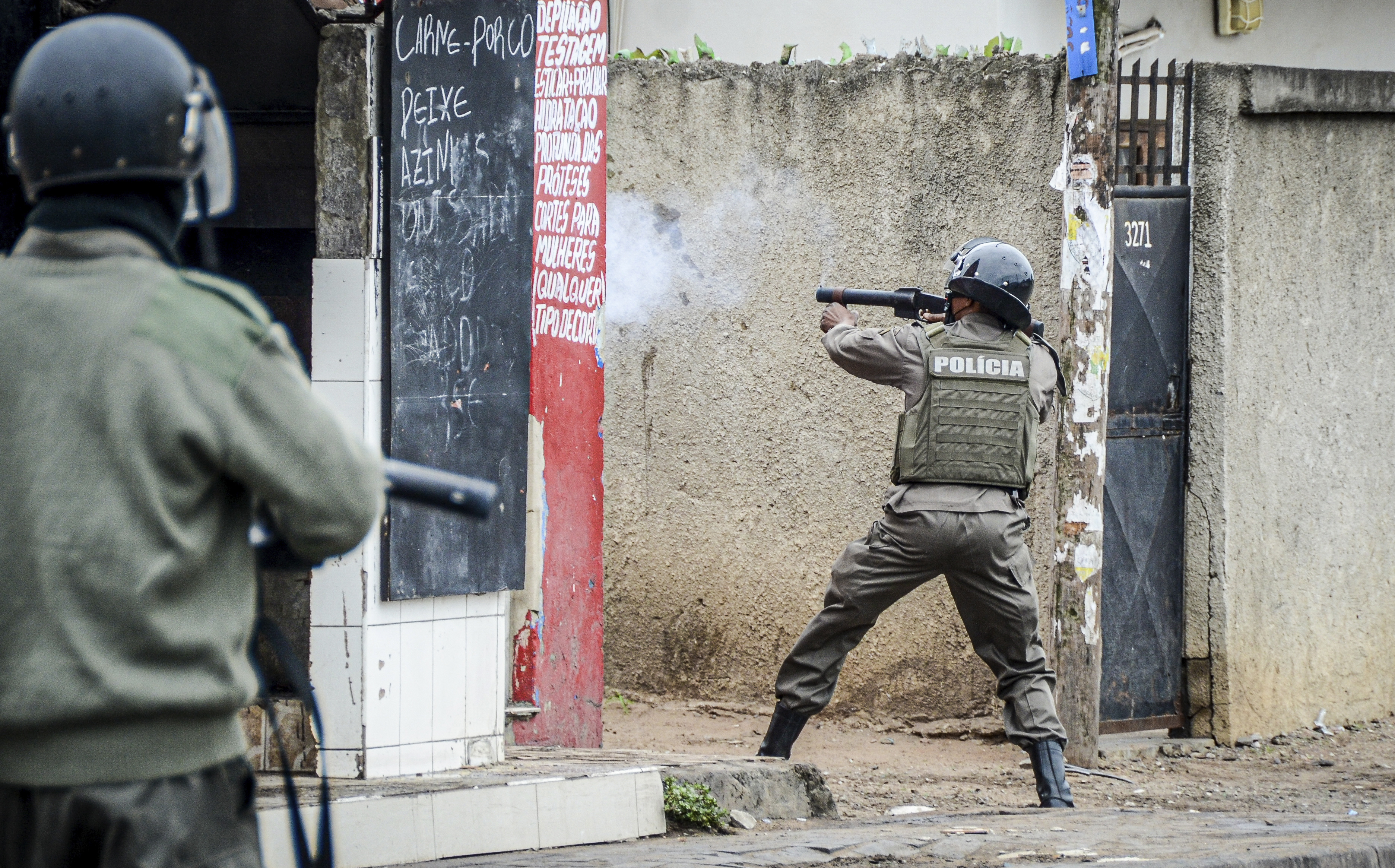 A police officer aims his weapon at protesters in Maputo, Mozambique, Thursday, Nov. 7, 2024. Protesters dispute the outcome of the Oct. 9 elections that saw the ruling Frelimo party extend its 49-year rule. (AP Photo/Carlos Uqueio)