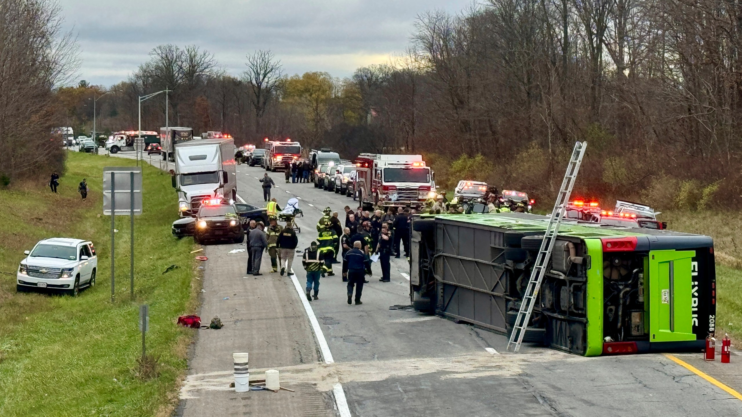 First responders investigate the scene where a tour bus rolled over on westbound Interstate 490 critically injuring one and sending all 28 passengers to area hospitals, Thursday, Nov. 7, 2024, in Chili, N.Y. (Monroe County Sheriff's Office via AP)