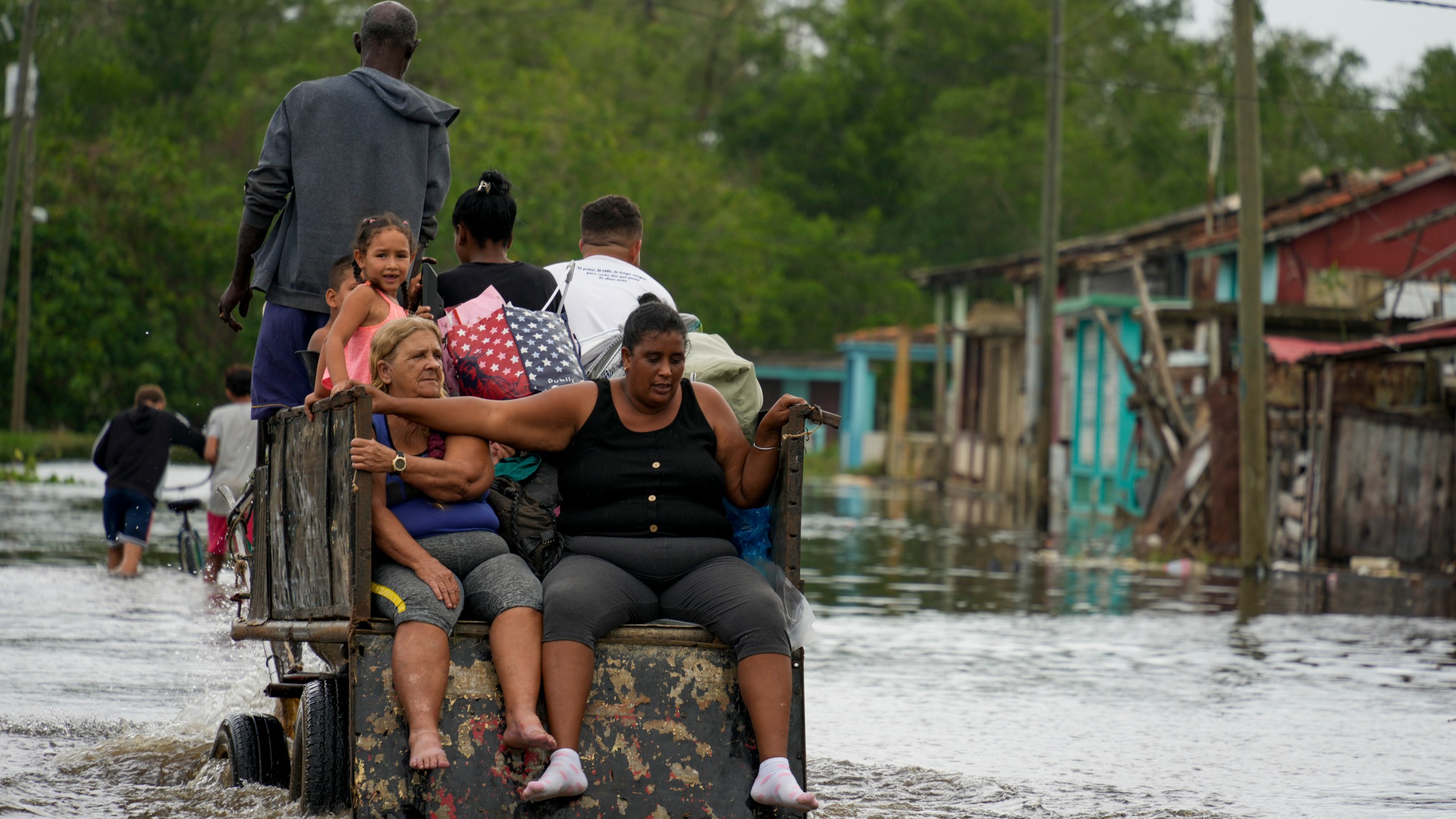 Residents ride through a flooded street on a horse-drawn cart after Hurricane Rafael passed through Batano, Cuba, Thursday, Nov. 7, 2024. (AP Photo/Ramon Espinosa)