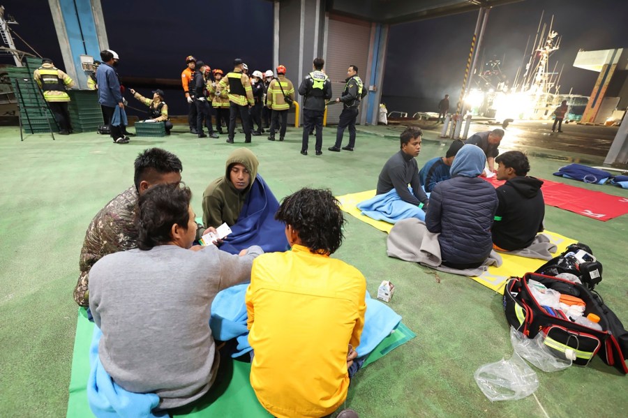 Rescued crew members of a fishing boat wait for transfer to a hospital at a port on Jeju Island, South Korea, Friday, Nov. 8, 2024. (Park Ji-ho/Yonhap via AP)