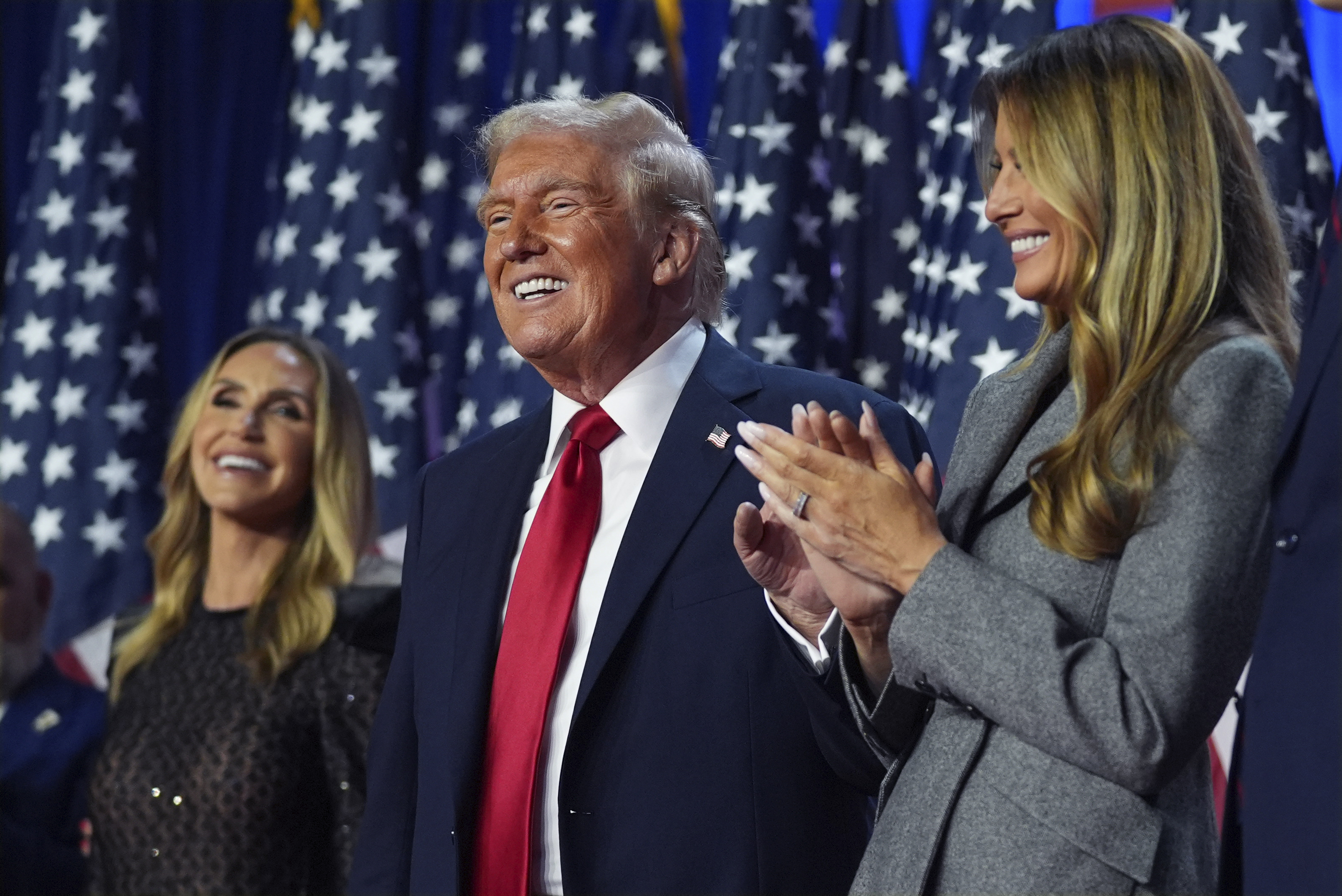 Republican presidential nominee former President Donald Trump stands on stage with former first lady Melania Trump, as Lara Trump watches, at an election night watch party at the Palm Beach Convention Center, Wednesday, Nov. 6, 2024, in West Palm Beach, Fla. (AP Photo/Evan Vucci)