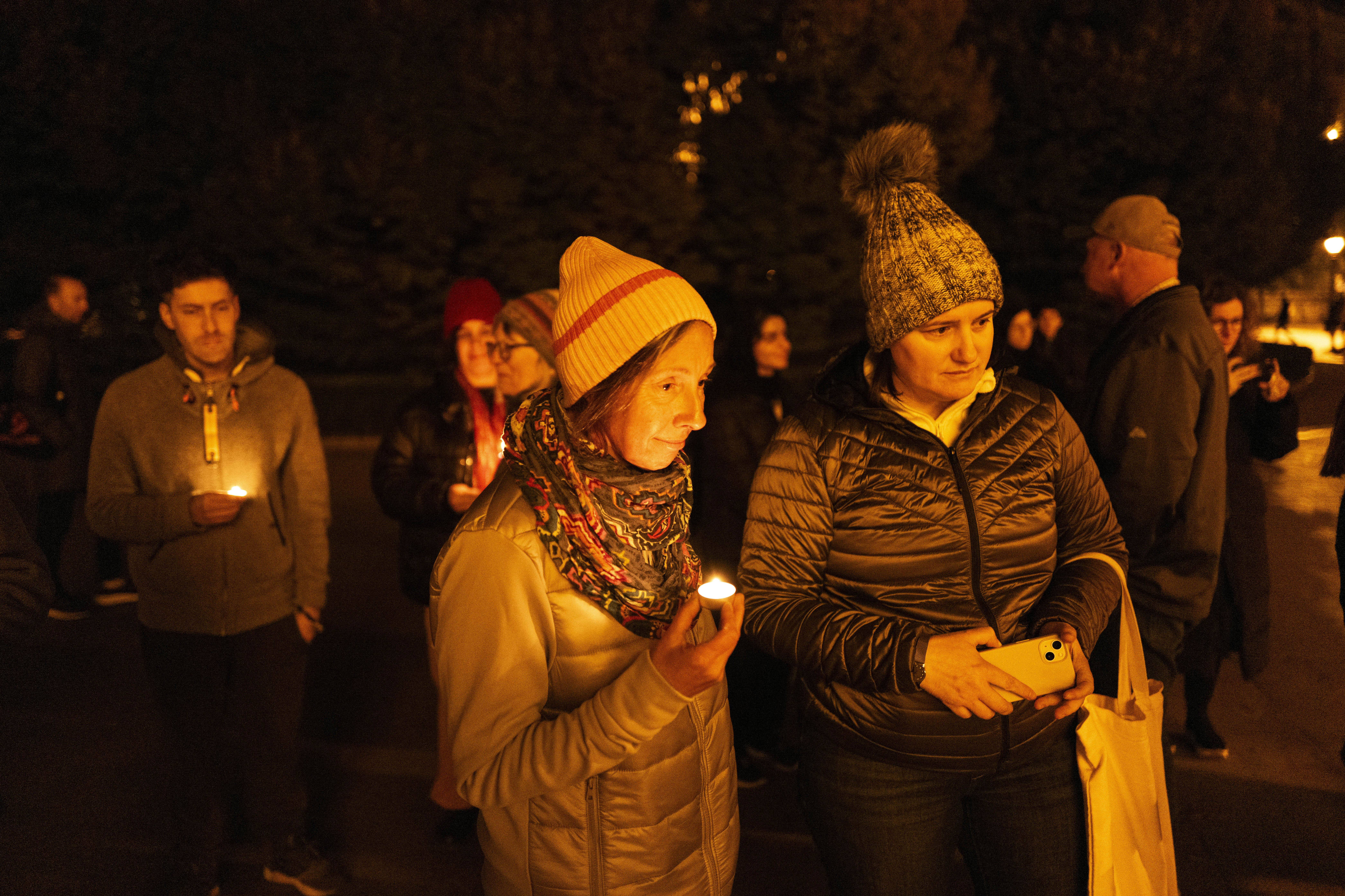 Friends hold candles while remembering Mackenzie Michalski, an 31-year-old American tourist who was murdered while on vacation, during a candlelight vigil in Budapest, Hungary, Saturday, Nov. 9, 2024. (AP Photo/Bela Szandelszky)