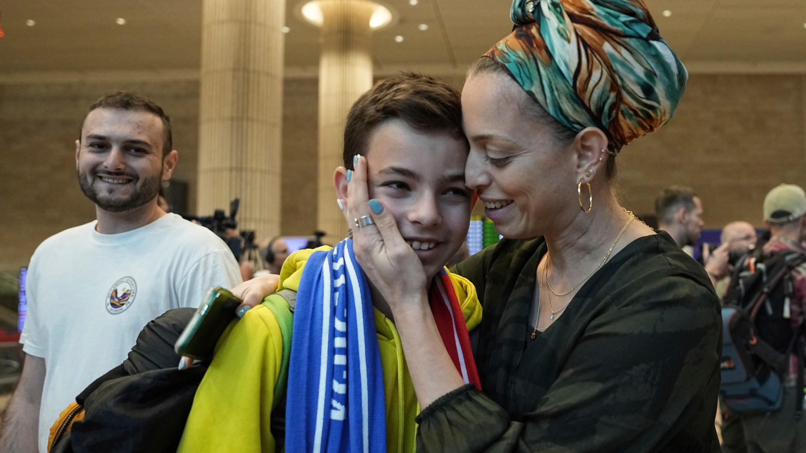 A woman embraces her son, who is a fan of Maccabi Tel Aviv, as he arrives at Israel's Ben-Gurion International Airport on a flight from Amsterdam, where Israeli soccer fans were attacked following a match between the Israeli club and Ajax Amsterdam in Lod, Israel, Friday, Nov. 8, 2024. (AP Photo/Tsafrir Abayov)