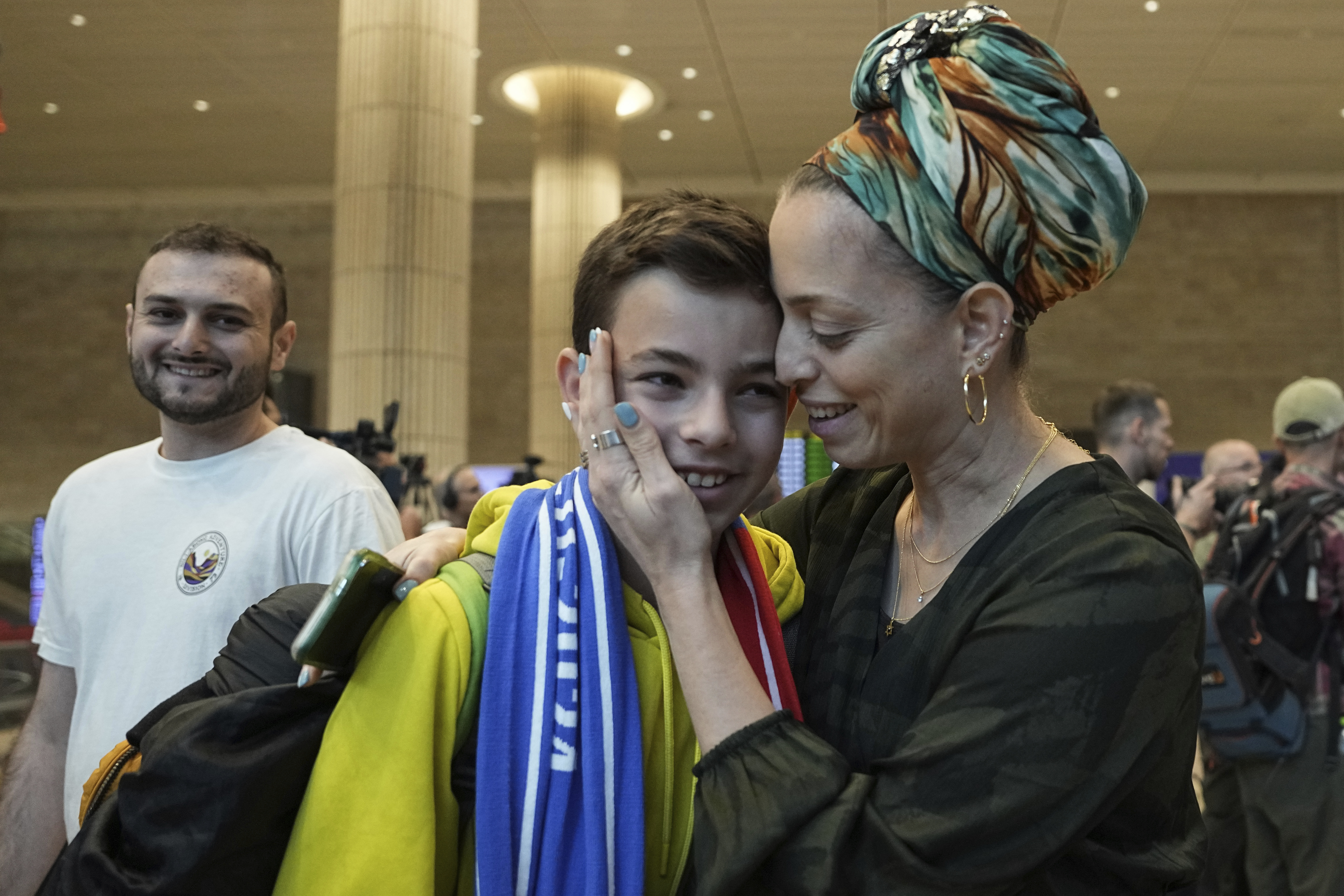 A woman embraces her son, who is a fan of Maccabi Tel Aviv, as he arrives at Israel's Ben-Gurion International Airport on a flight from Amsterdam, where Israeli soccer fans were attacked following a match between the Israeli club and Ajax Amsterdam in Lod, Israel, Friday, Nov. 8, 2024. (AP Photo/Tsafrir Abayov)