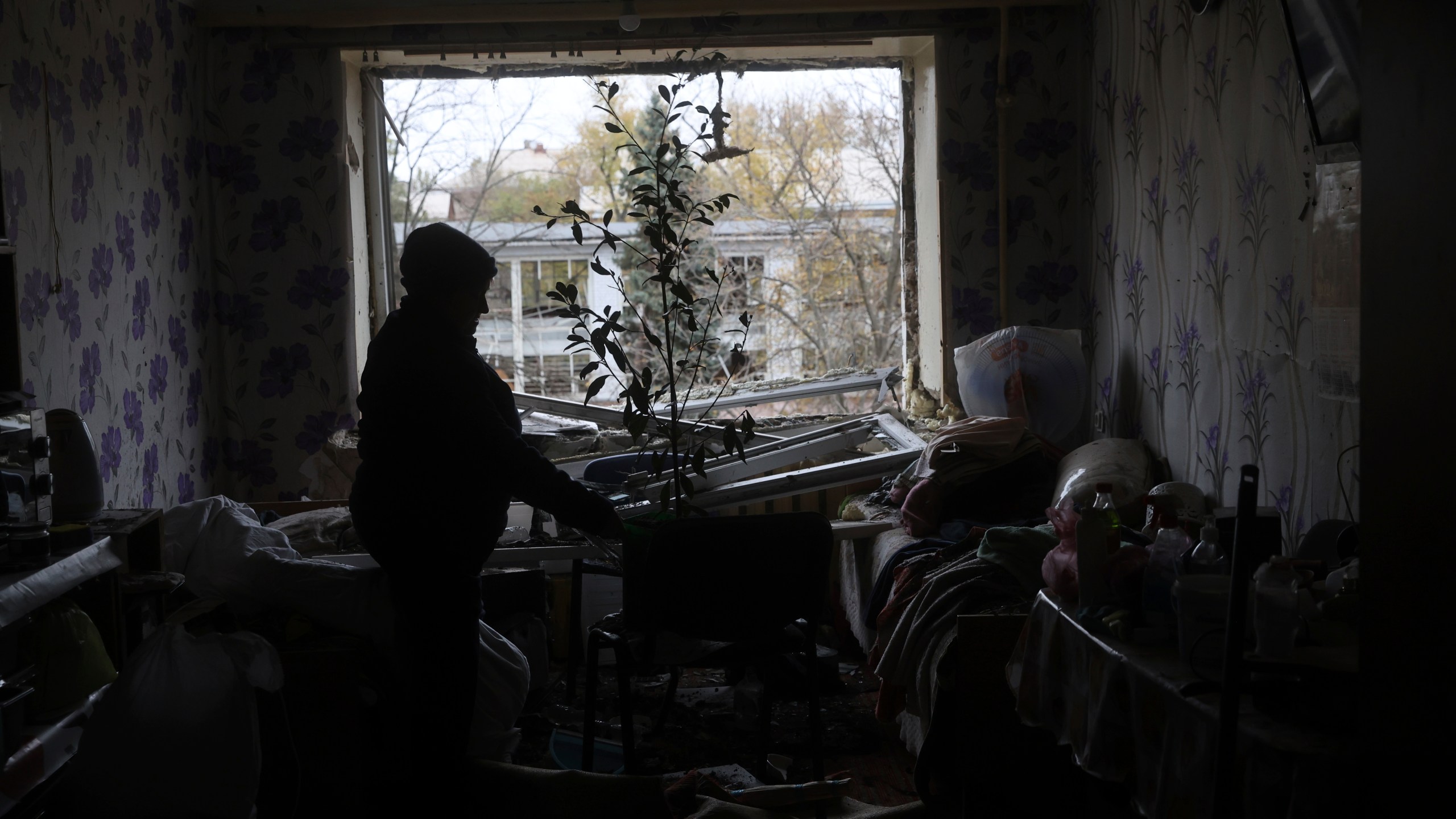 A woman clear the rubble inside her apartment at a hostel for displaced persons damaged by a Russian strike in Zaporizhzhia, Ukraine, Nov. 11, 2024. (AP Photo/Kateryna Klochko)