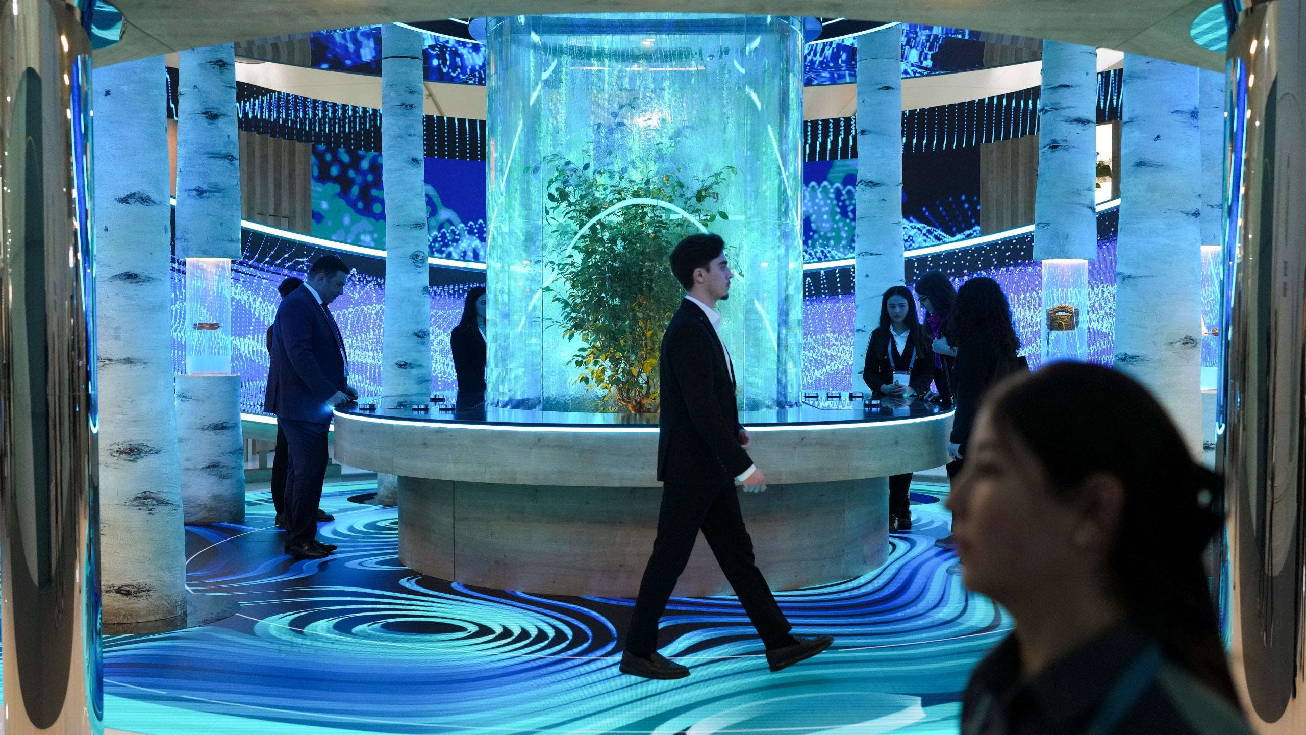 People walk through an exhibit in the Green Zone at the COP29 U.N. Climate Summit, Monday, Nov. 11, 2024, in Baku, Azerbaijan. (AP Photo/Sergei Grits)