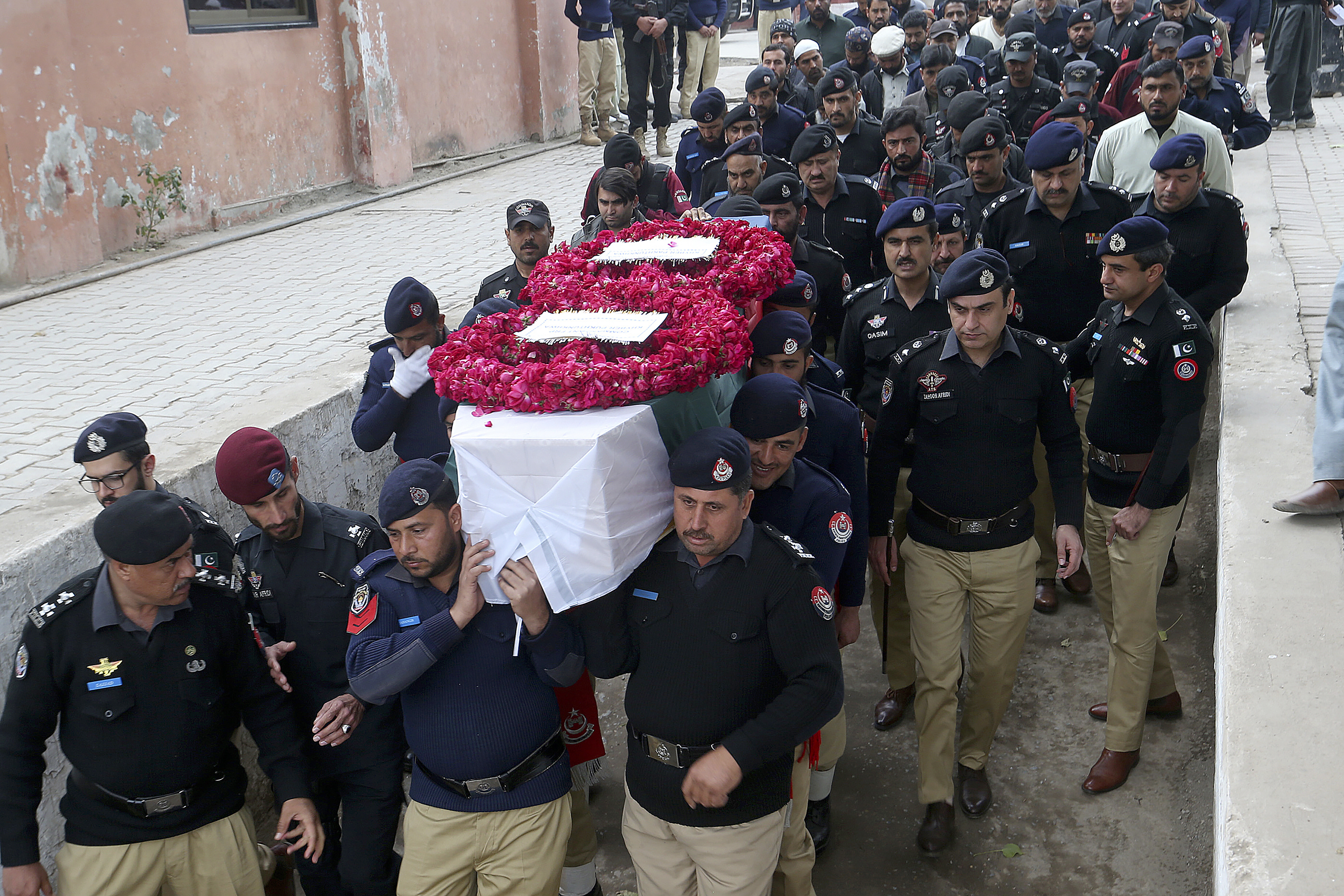 FILE - Police officers carry the casket of a fellow police officer, a victim of Monday's suicide bombing, for his funeral in Peshawar, Pakistan, Feb. 2, 2023. (AP Photo/Muhammad Sajjad, File)