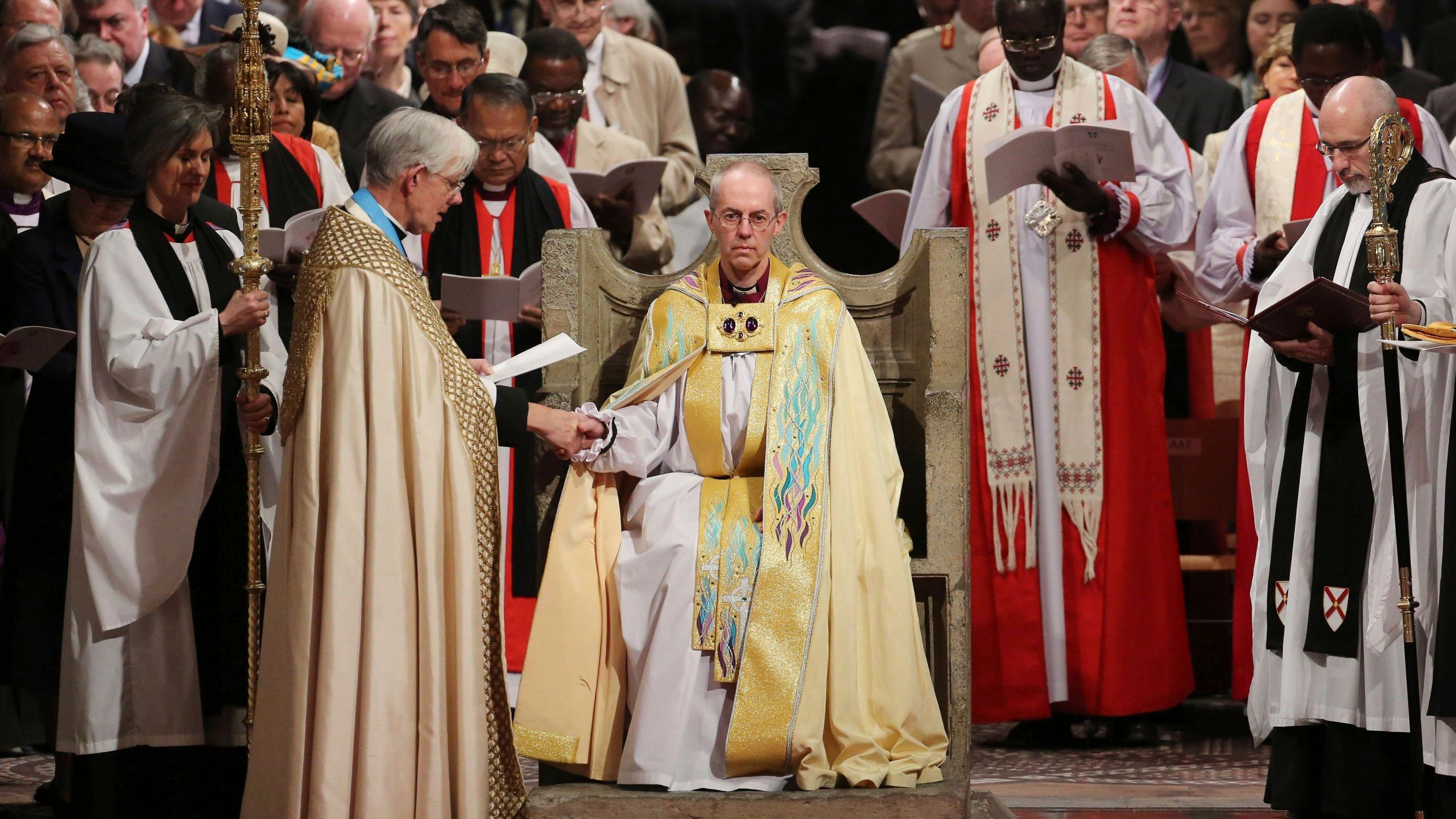 FILE - The Most Reverend Justin Welby sits in the Chair of St Augistine as the Dean of Canterbury Robert Willis takes him by the hand during his enthronement service to become Archbishop of Canterbury at Canterbury Cathedral in Canterbury, England, Thursday, March 21, 2013. (Gareth Fuller, Pool Photo via AP, File)