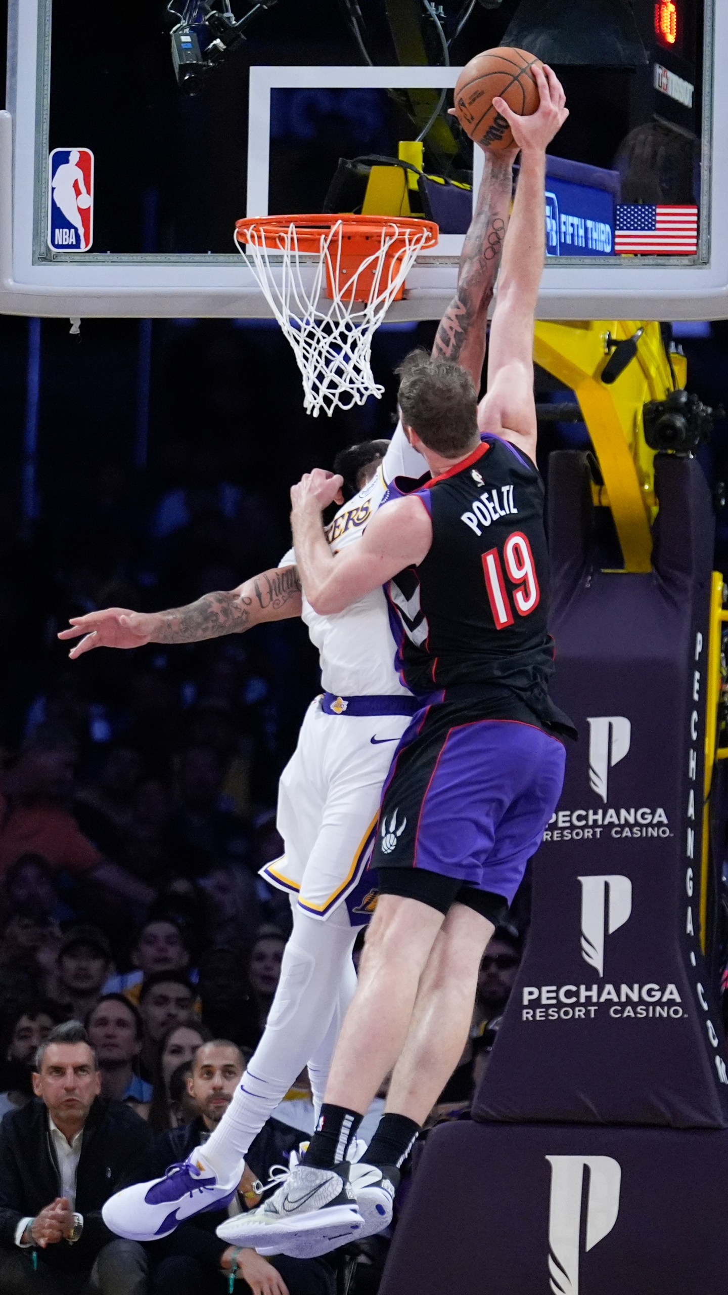 Los Angeles Lakers forward Anthony Davis, left, blocks a shot from Toronto Raptors center Jakob Poeltl (19) during the second half of an NBA basketball game Sunday, Nov. 10, 2024, in Los Angeles. (AP Photo/Marcio Jose Sanchez)