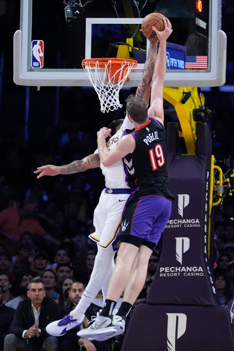 Los Angeles Lakers forward Anthony Davis, left, blocks a shot from Toronto Raptors center Jakob Poeltl (19) during the second half of an NBA basketball game Sunday, Nov. 10, 2024, in Los Angeles. (AP Photo/Marcio Jose Sanchez)