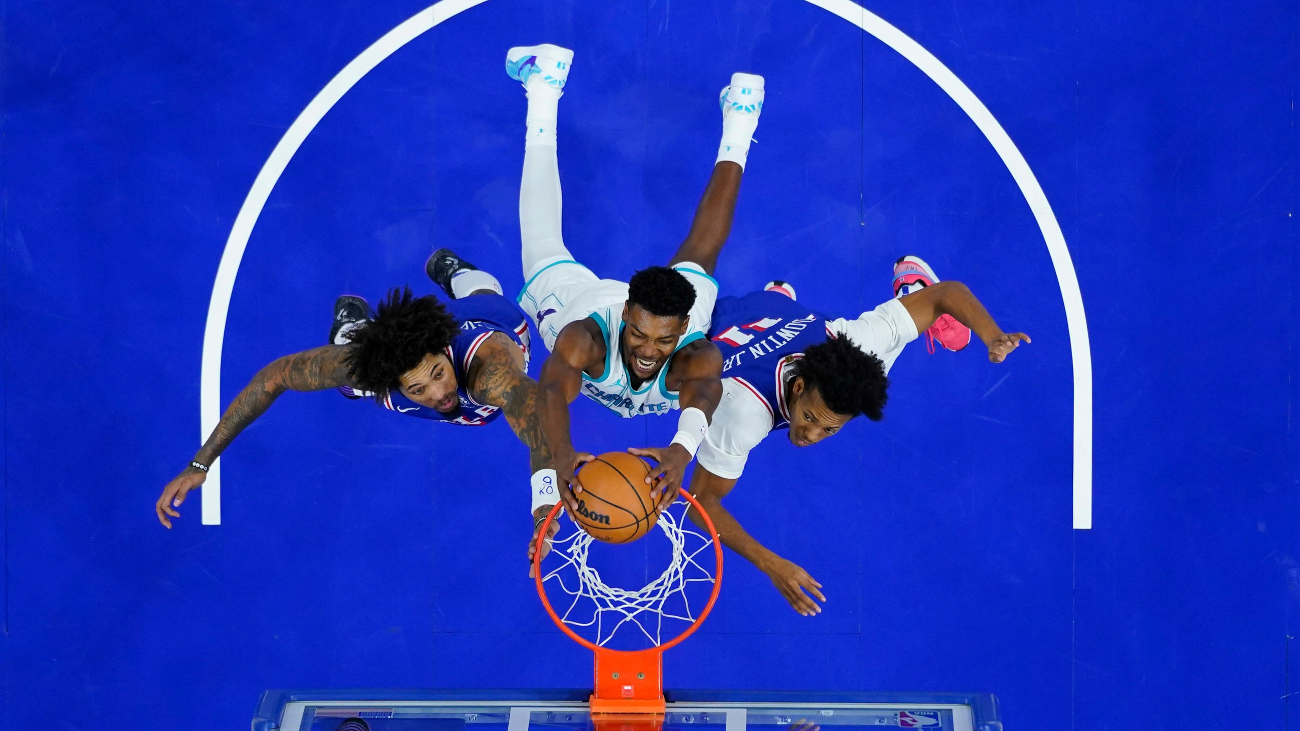 Charlotte Hornets' Brandon Miller, center, dunks between Philadelphia 76ers' Kelly Oubre Jr., left, and Jeff Dowtin Jr. during the second half of an NBA basketball game, Sunday, Nov. 10, 2024, in Philadelphia. (AP Photo/Matt Slocum)