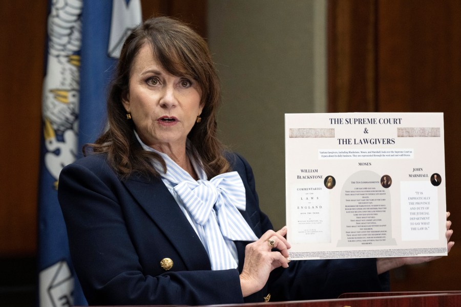 FILE - Louisiana Attorney General Liz Murrill speaks holds up a mini-display showing the Ten Commandments during a press conference regarding the Ten Commandments in schools, Aug. 5, 2024, in Baton Rouge, La. (Hilary Scheinuk/The Advocate via AP, File)