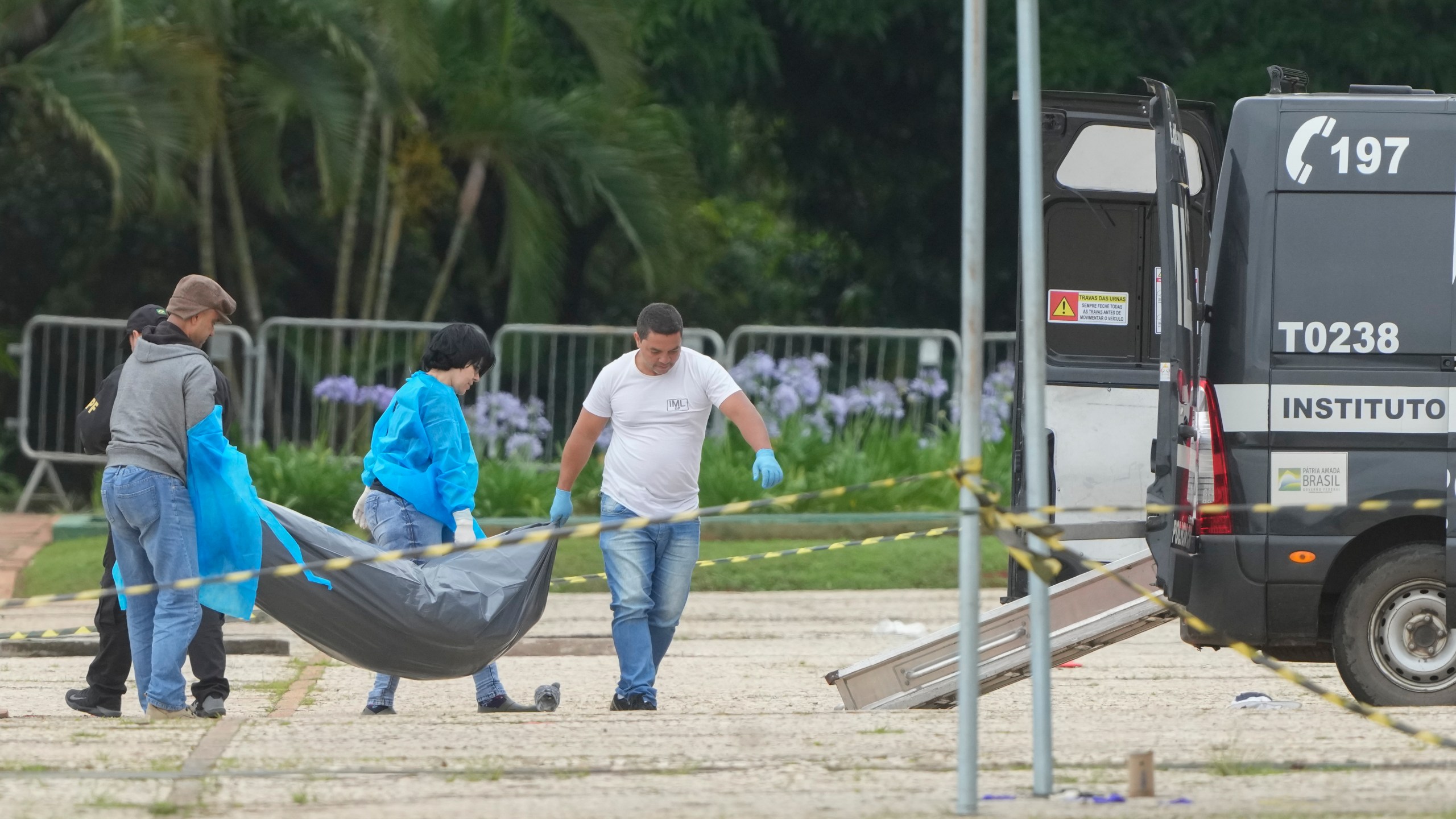 Forensic officers collect a body outside the Supreme Court following an explosion the previous night in Brasilia, Brazil, Thursday, Nov. 14, 2024. (AP Photo/Eraldo Peres)