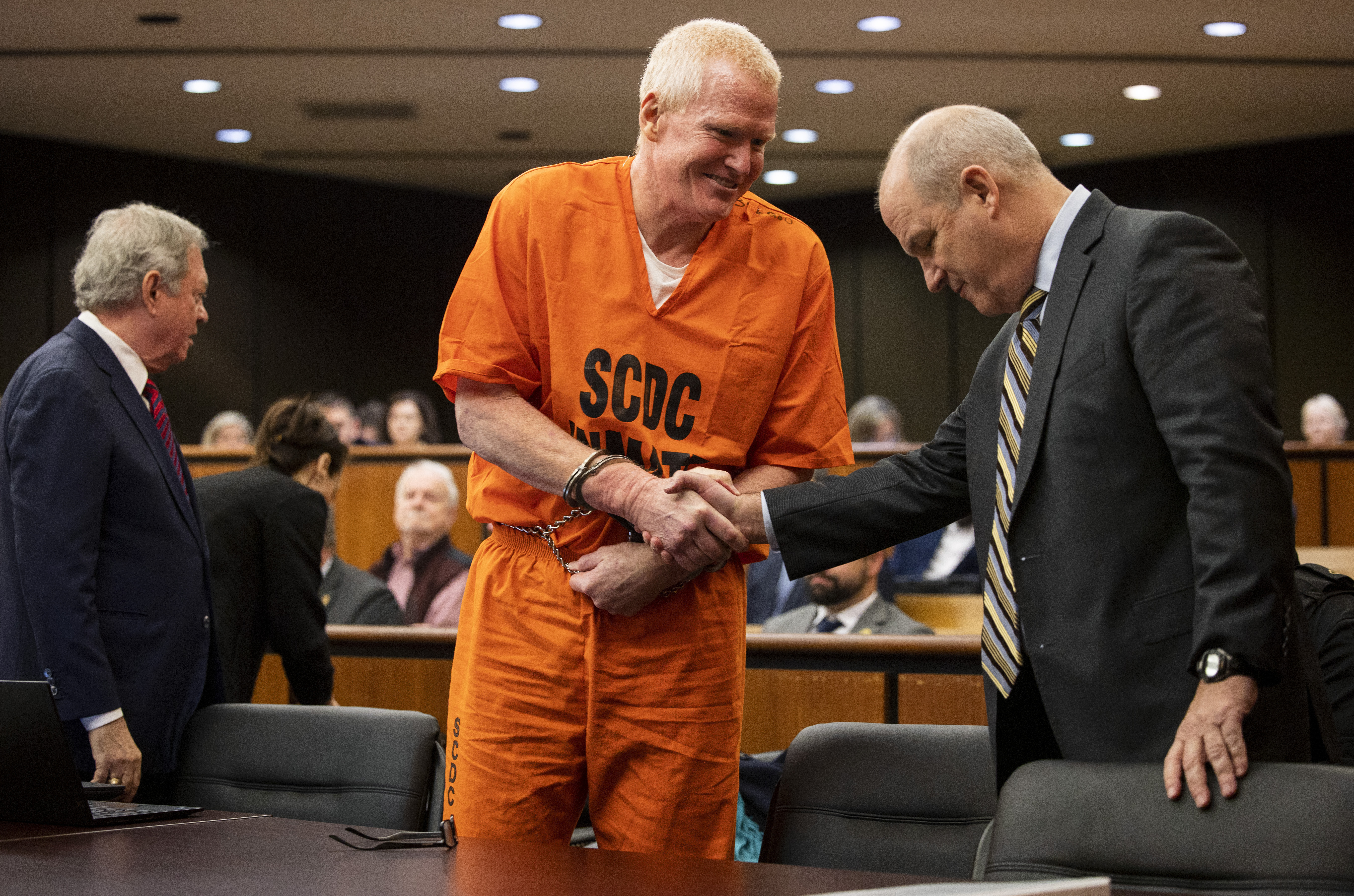 FILE- Alex Murdaugh, convicted of killing his wife, Maggie, and younger son, Paul, in June 2021, greets his defense attorney Jim Griffin before a hearing on the motion for a retrial, Tuesday, Jan. 16, 2024, at the Richland County Judicial Center, in Columbia, S.C. (Gavin McIntyre/The Post and Courier via AP, Pool, File)