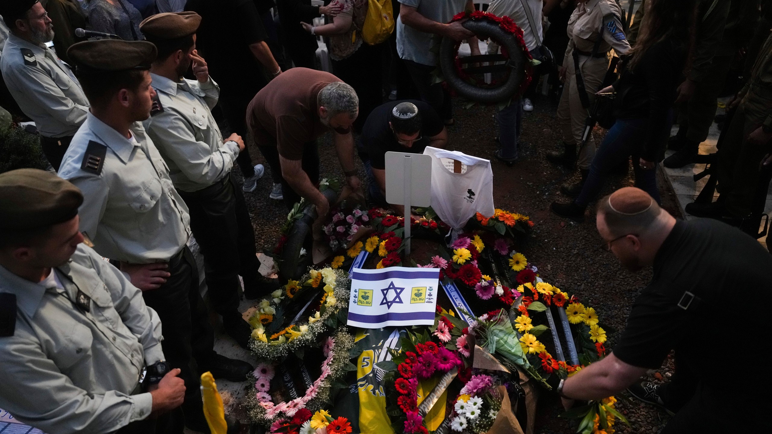 Mourners gather around the grave of Israeli soldier Capt. Itay Marcovich, who was killed in action in Lebanon, during his funeral in Kokhav Yair, Israel, Thursday, Nov. 14, 2024. (AP Photo/Ohad Zwigenberg)