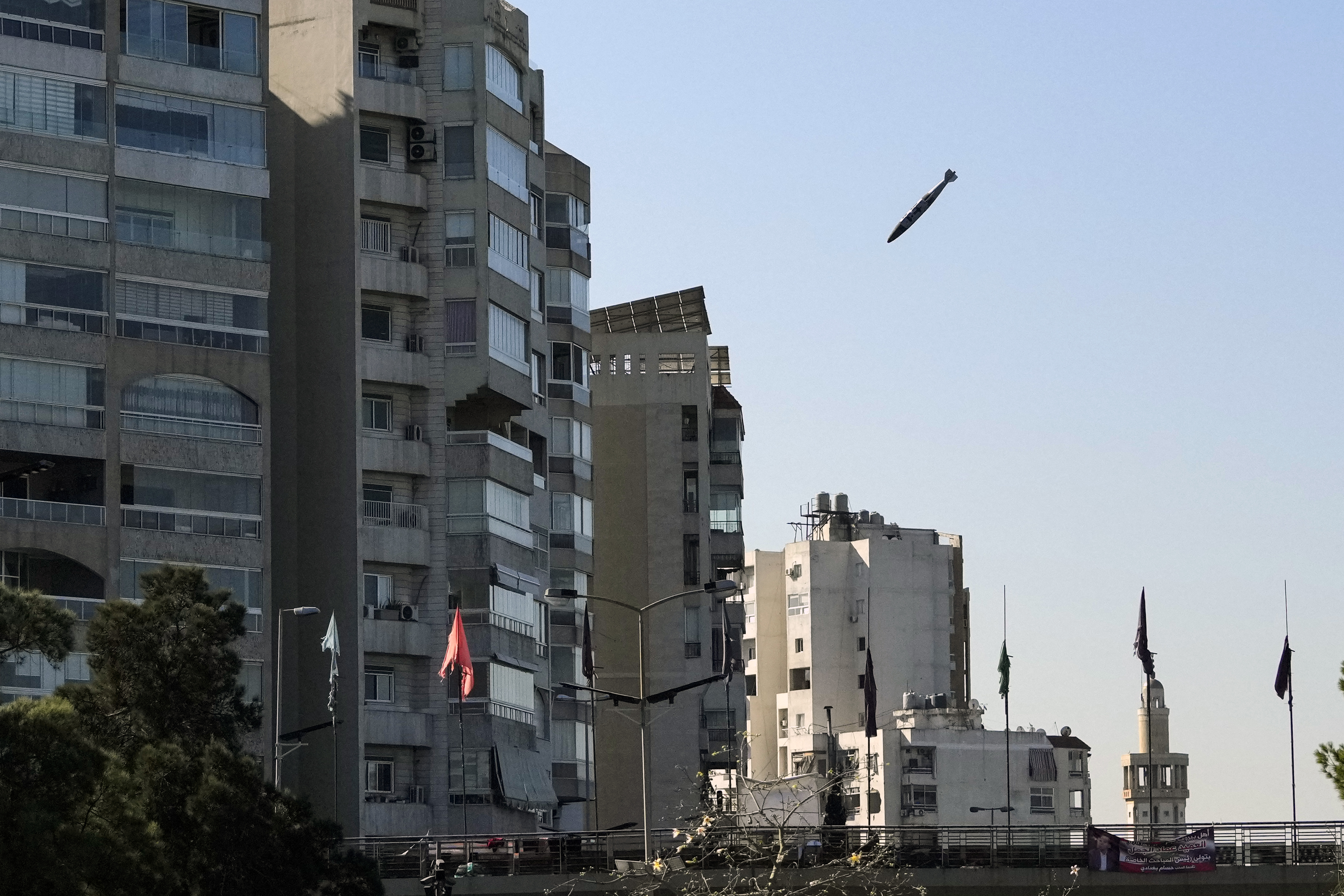 A bomb dropped from an Israeli jet prepares to hit a building in Tayouneh, Beirut, Lebanon, Friday, Nov. 15, 2024. (AP Photo/Hassan Ammar)