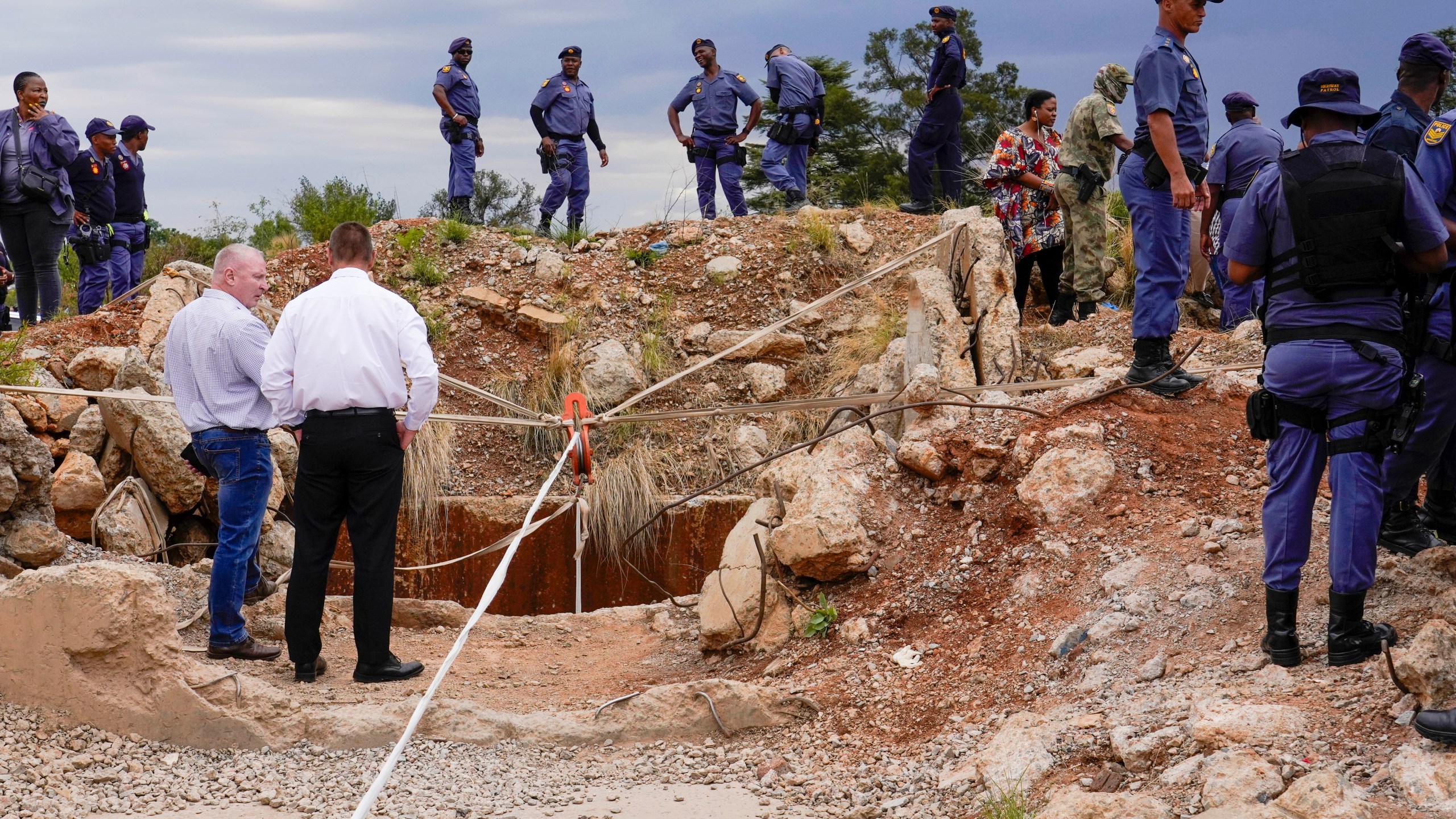 Police officers and private security personnel stand by the opening of a reformed gold mineshaft where illegal miners are trapped in Stilfontein, South Africa, Friday, Nov.15, 2024. (AP Photo/Denis Farrell)