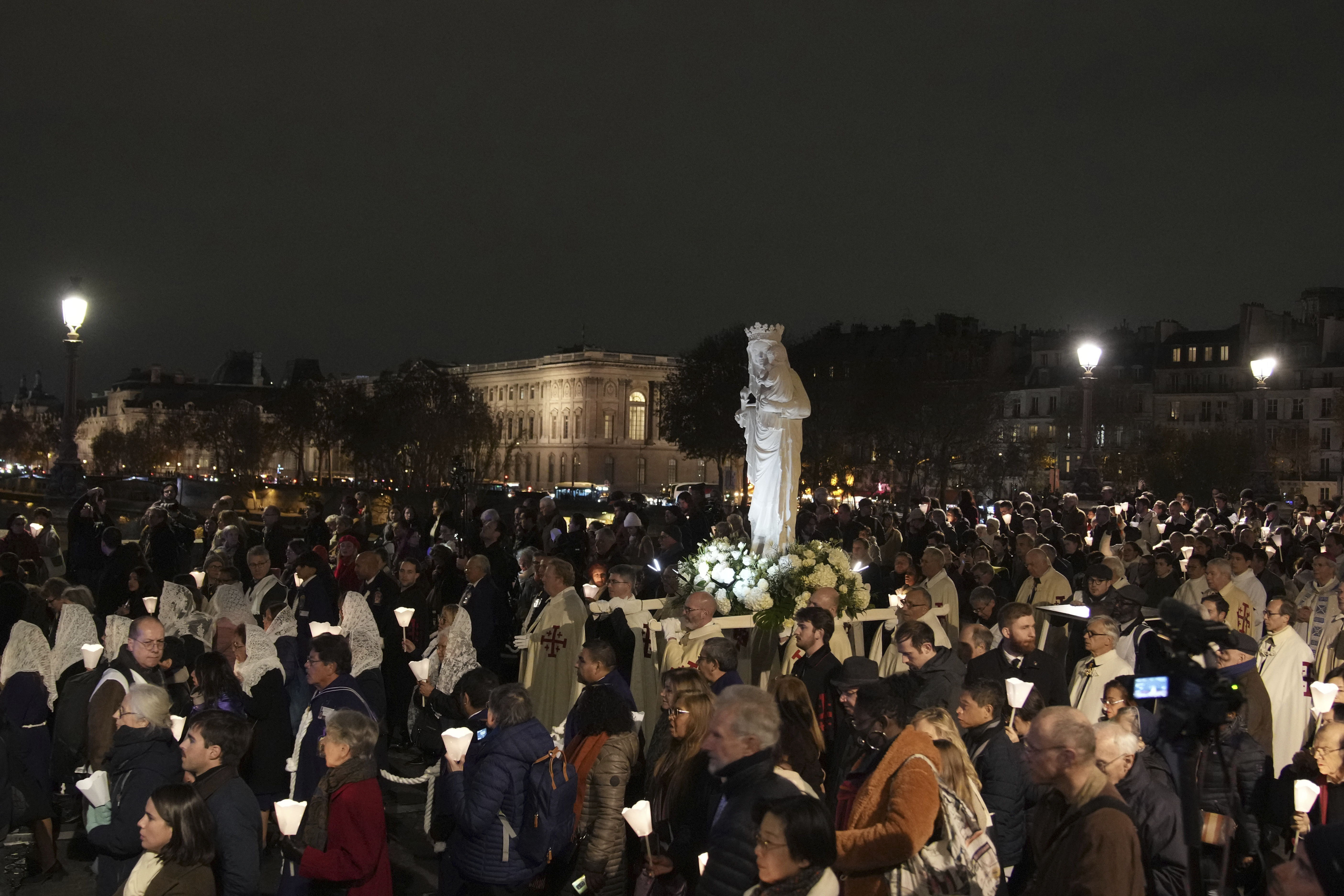 during a procession to bring the Virgin Mary statue from Saint-Germain l'Auxerrois church to Notre-Dame cathedral, Friday, Nov. 15, 2024 in Paris. (AP Photo/Christophe Ena)